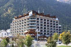 Modern hotel building nestled in a mountain landscape.