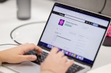 Person typing on a laptop computer screen.