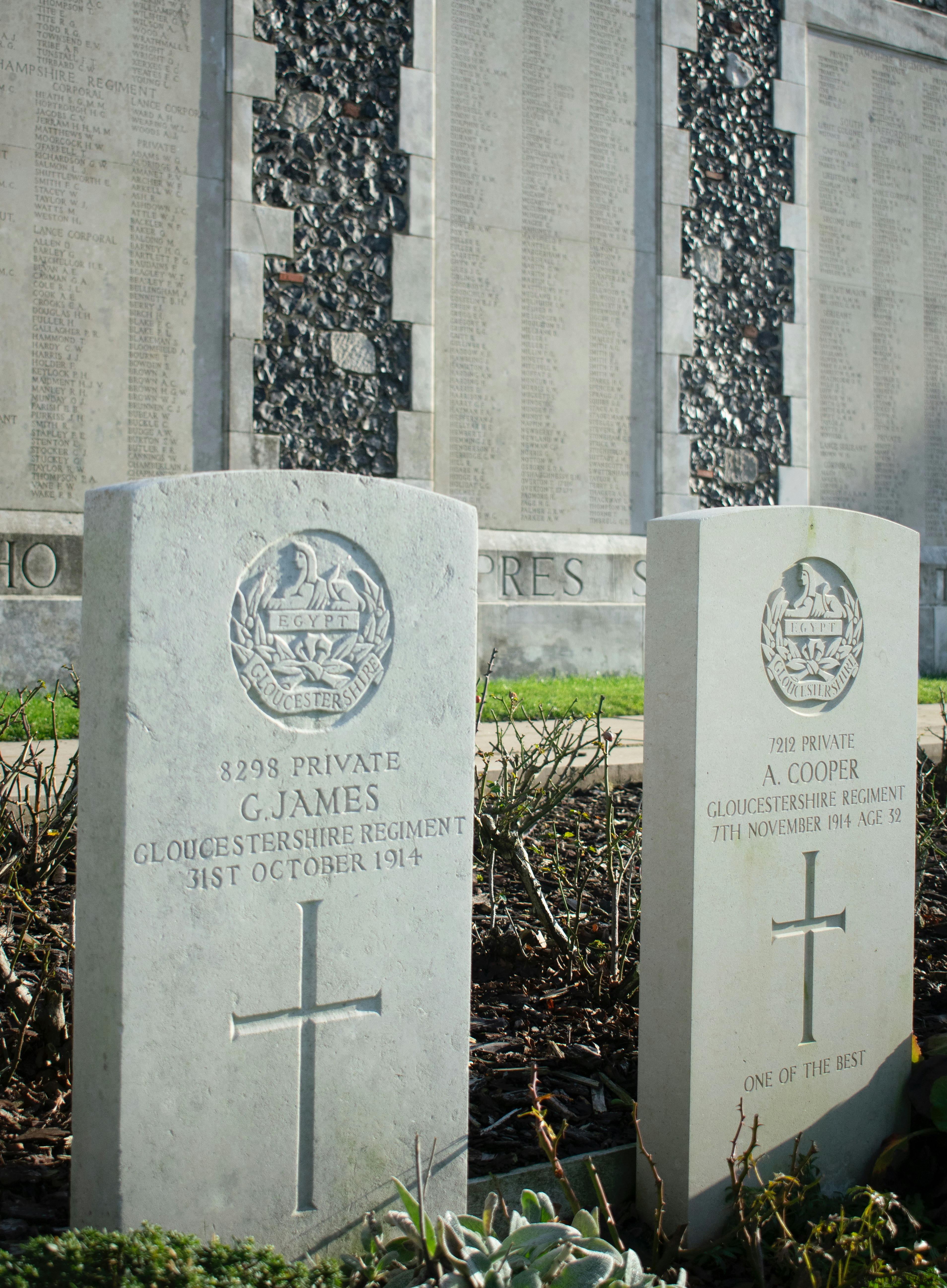 Two military gravestones with names and dates.