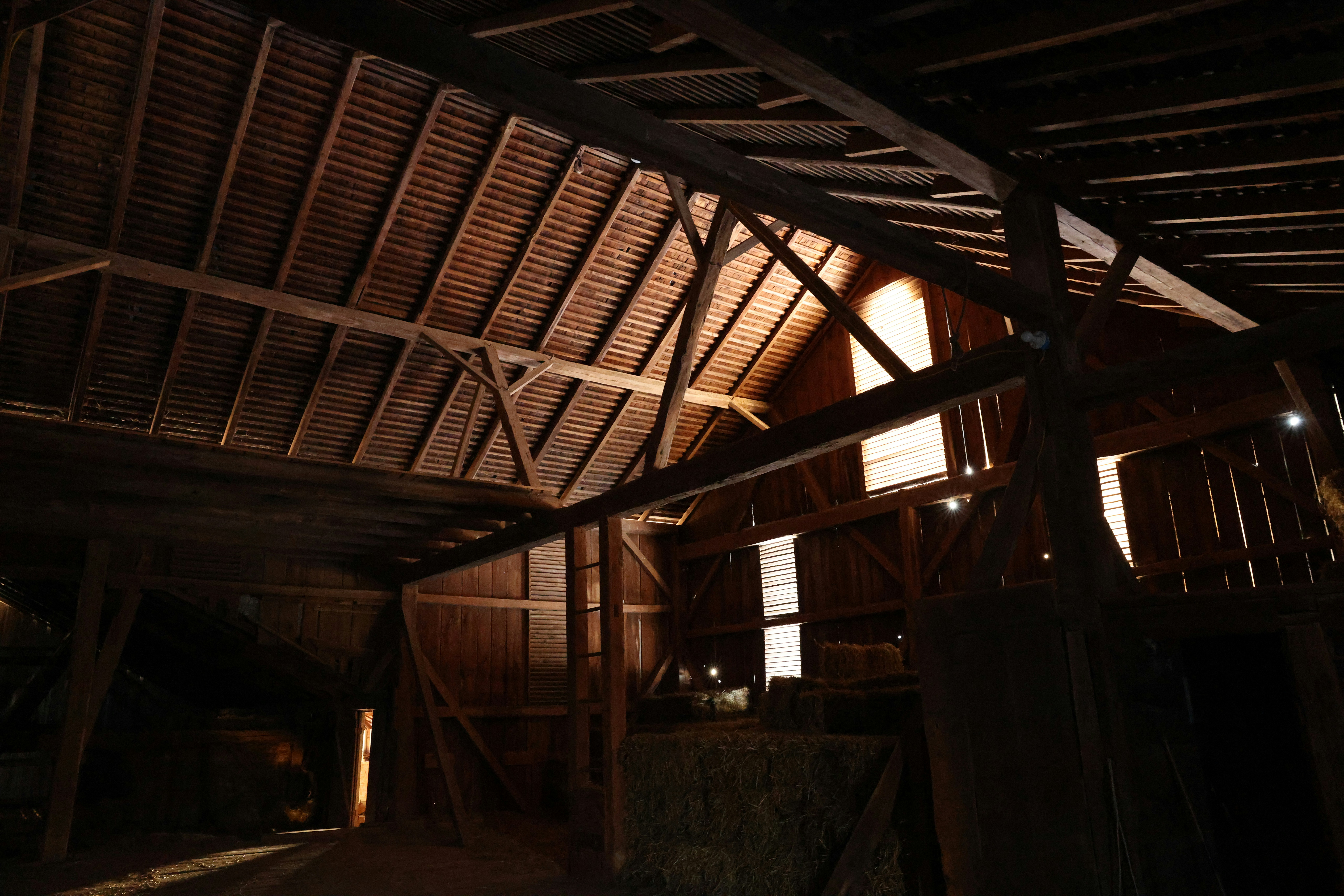 Interior of an old wooden barn with exposed beams.