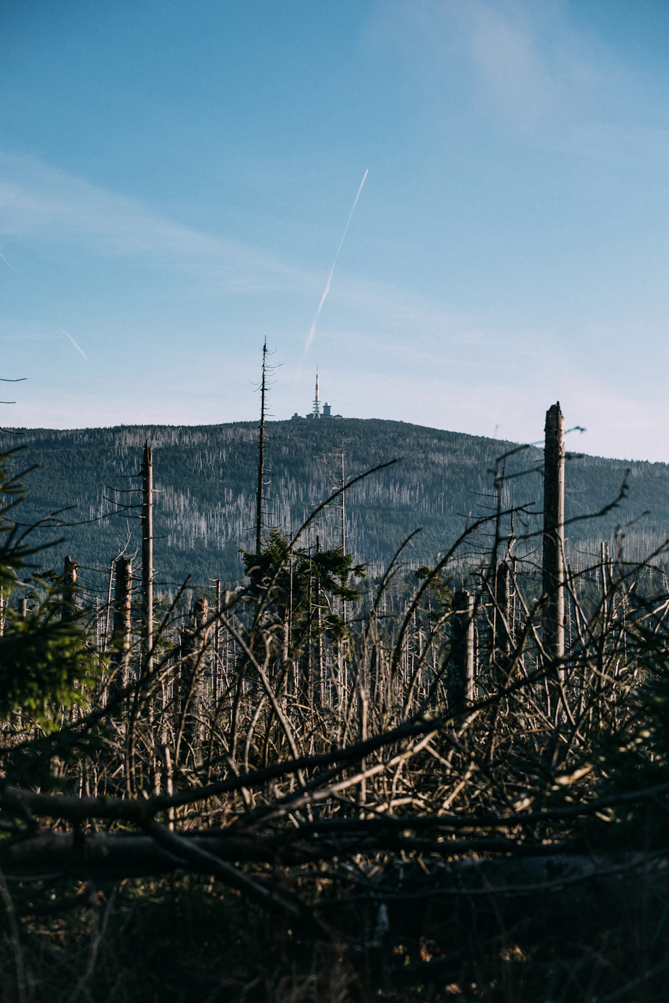 Mountain range with fog-shrouded peaks in background, partially obscured by hazy sky above