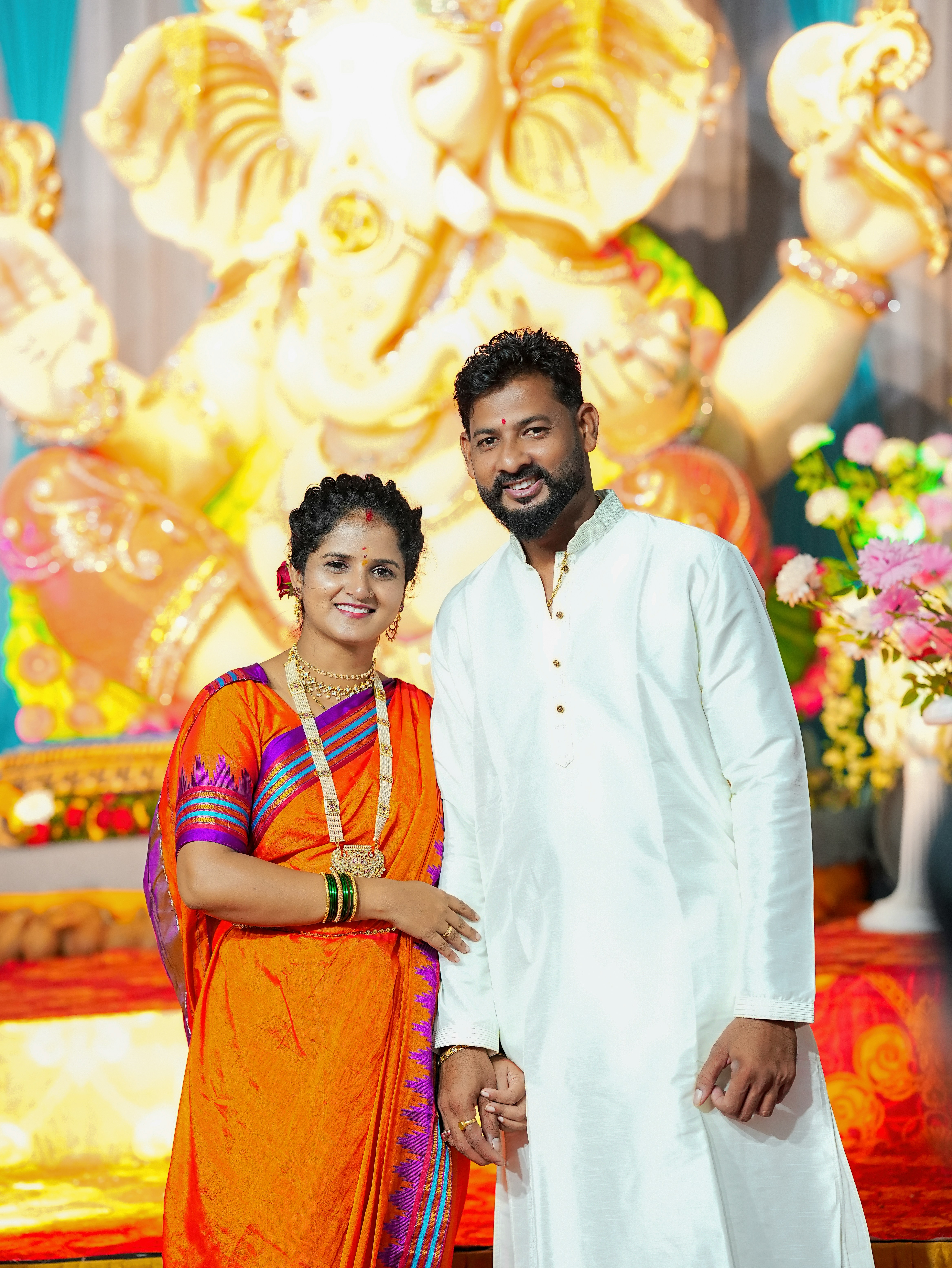 Paar posiert vor einer großen goldenen Ganesha-Statue