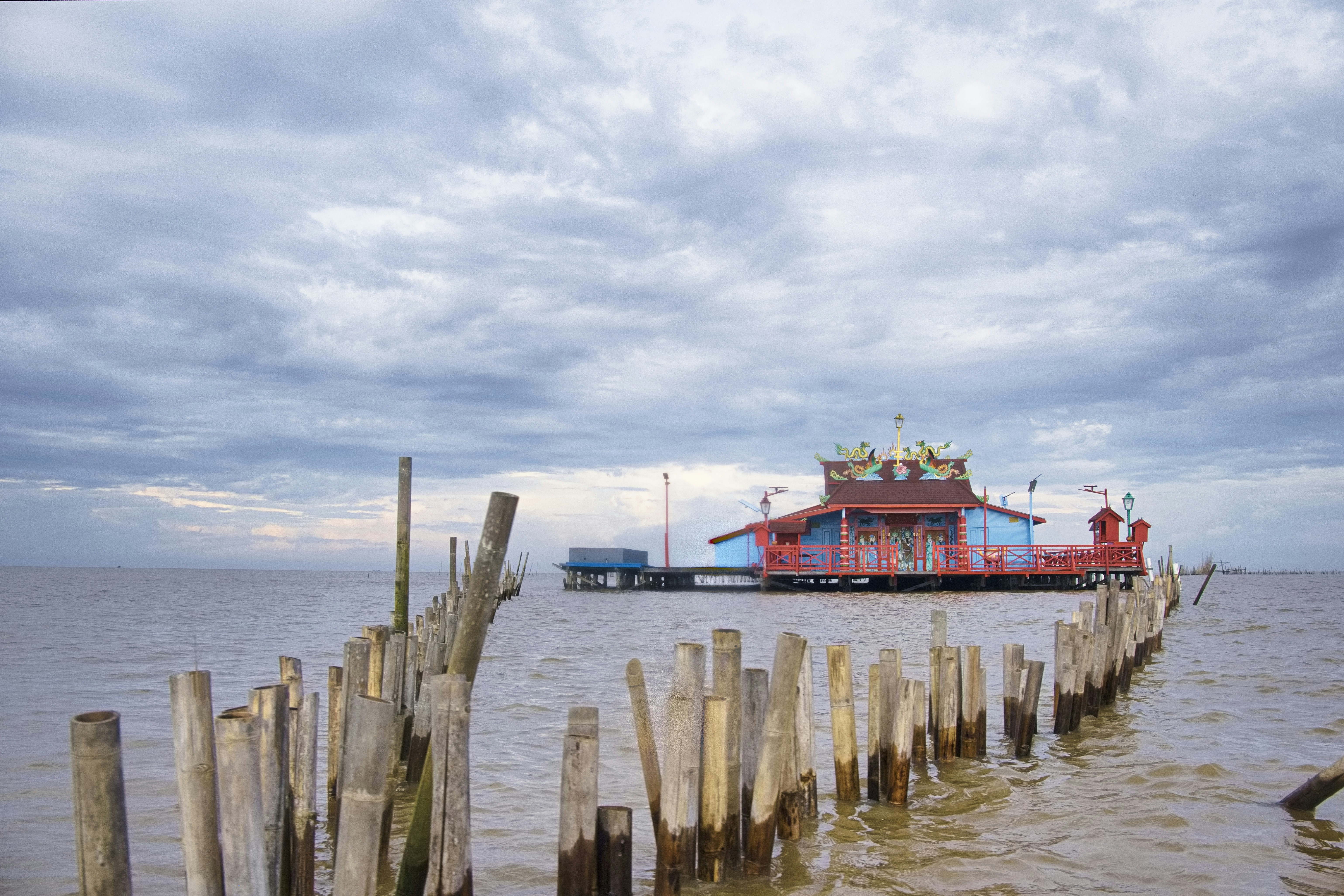 Colorful floating house on calm water under cloudy sky