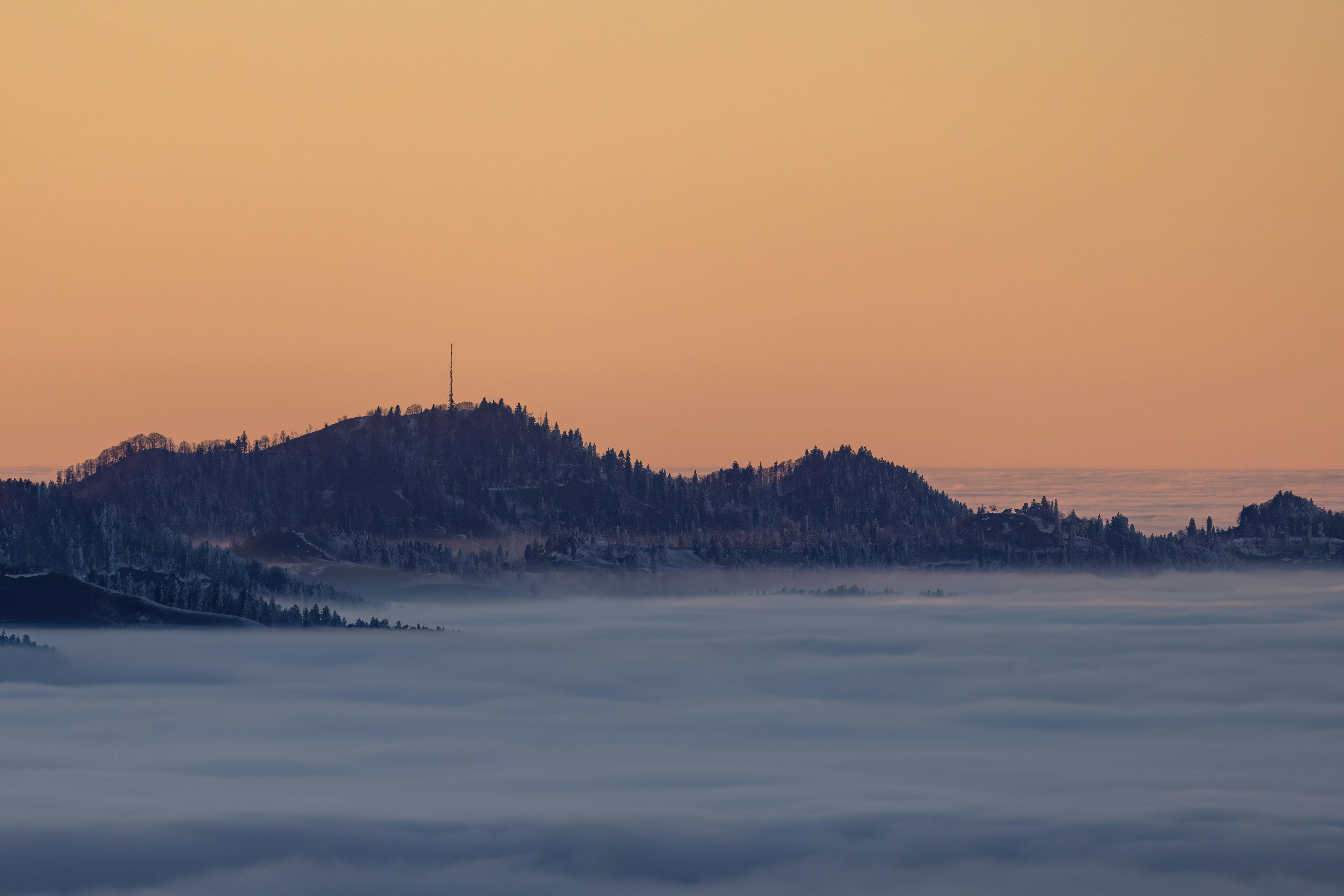 Chaîne de montagnes au-dessus du brouillard au coucher du soleil