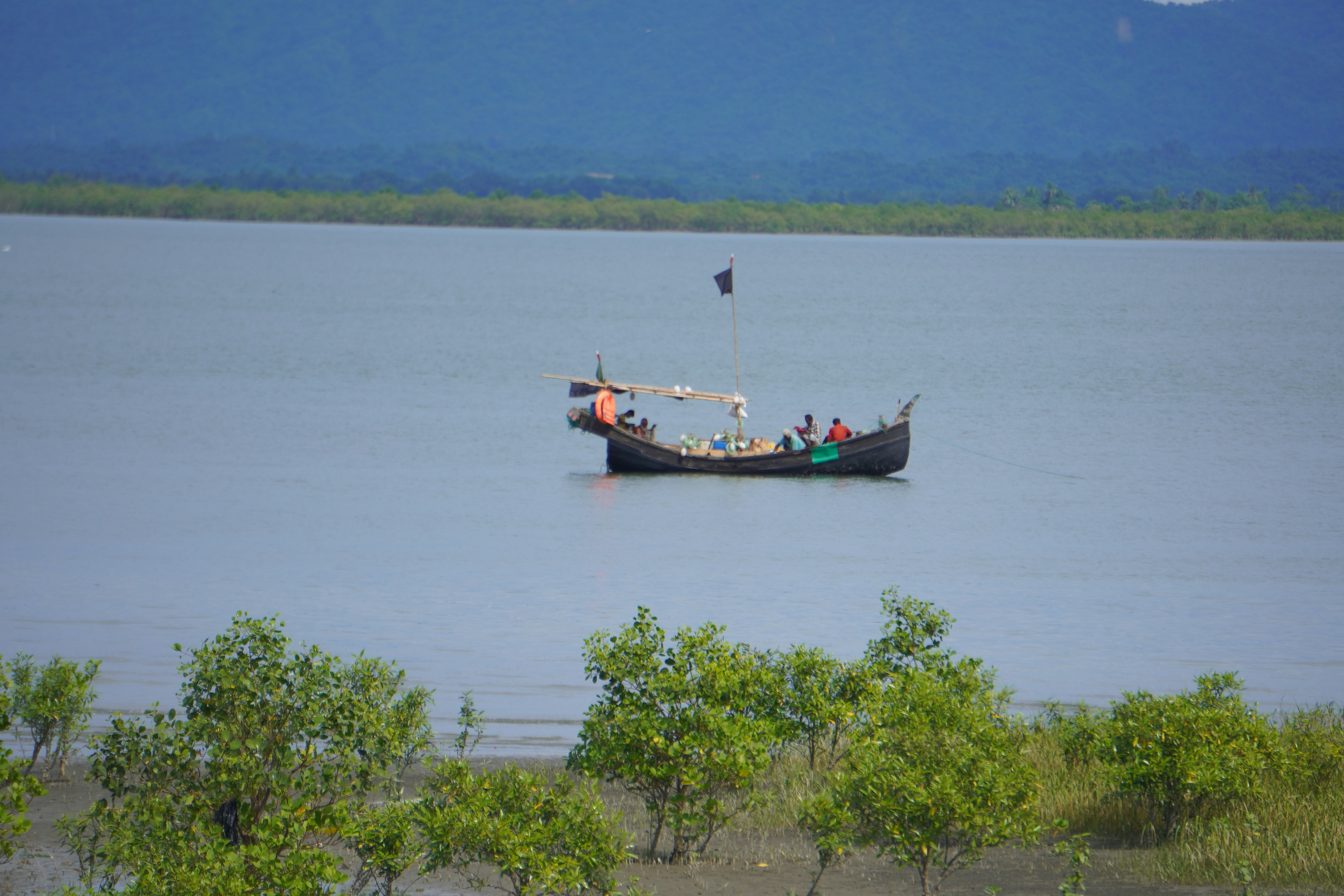Sebuah perahu nelayan berlayar di laut yang tenang.
