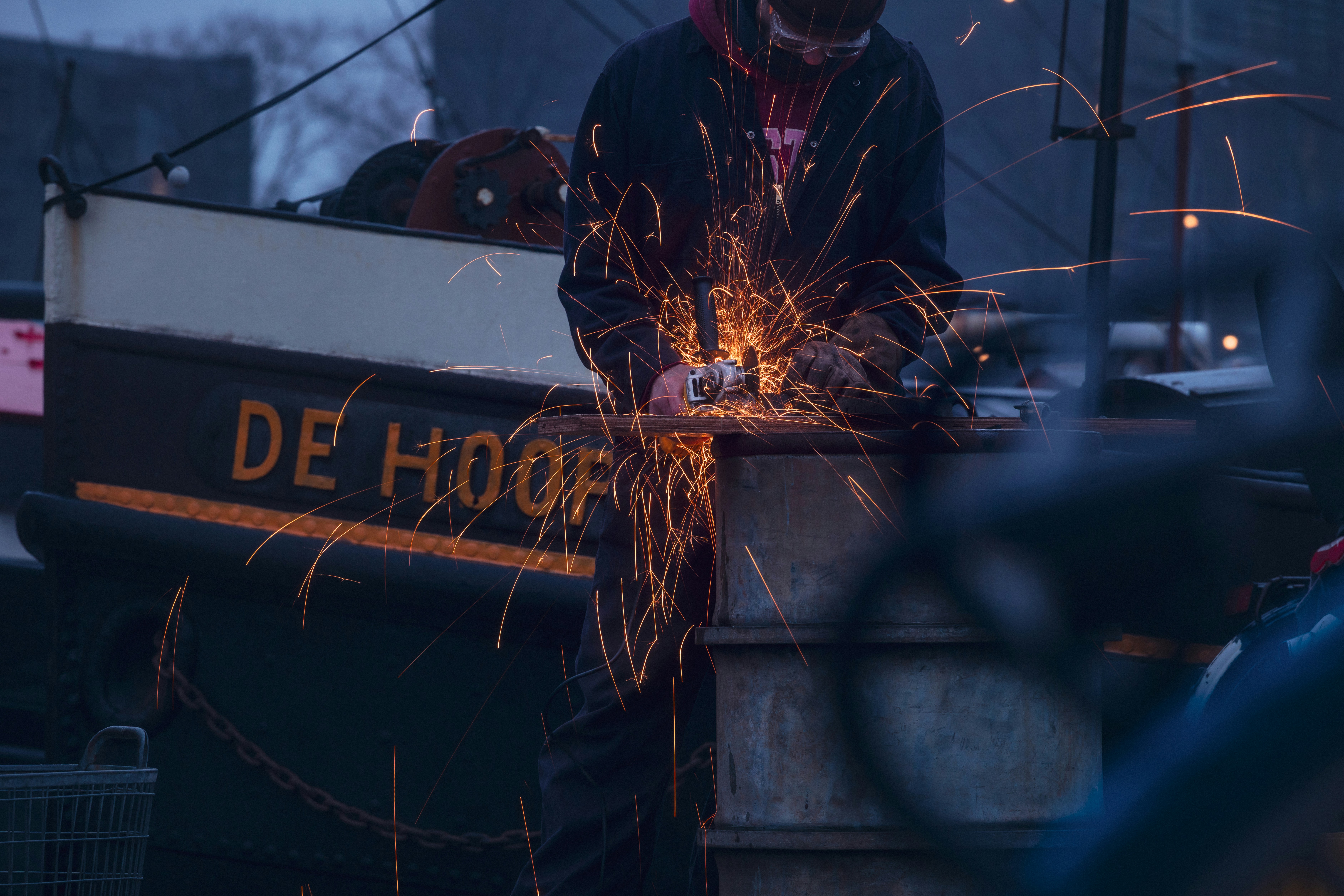 Pessoa triturando metal com faíscas voando