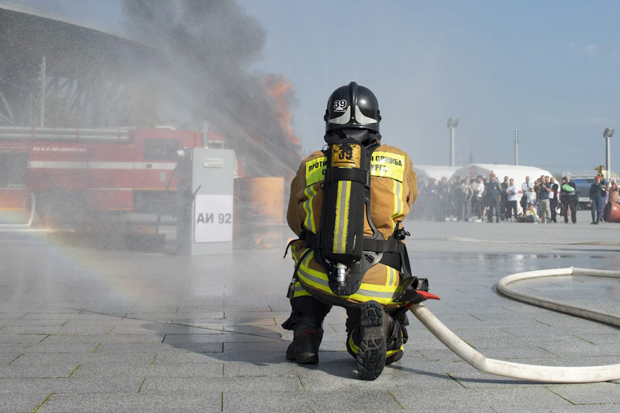 Vigile del fuoco che utilizza un getto d’acqua sulle fiamme
