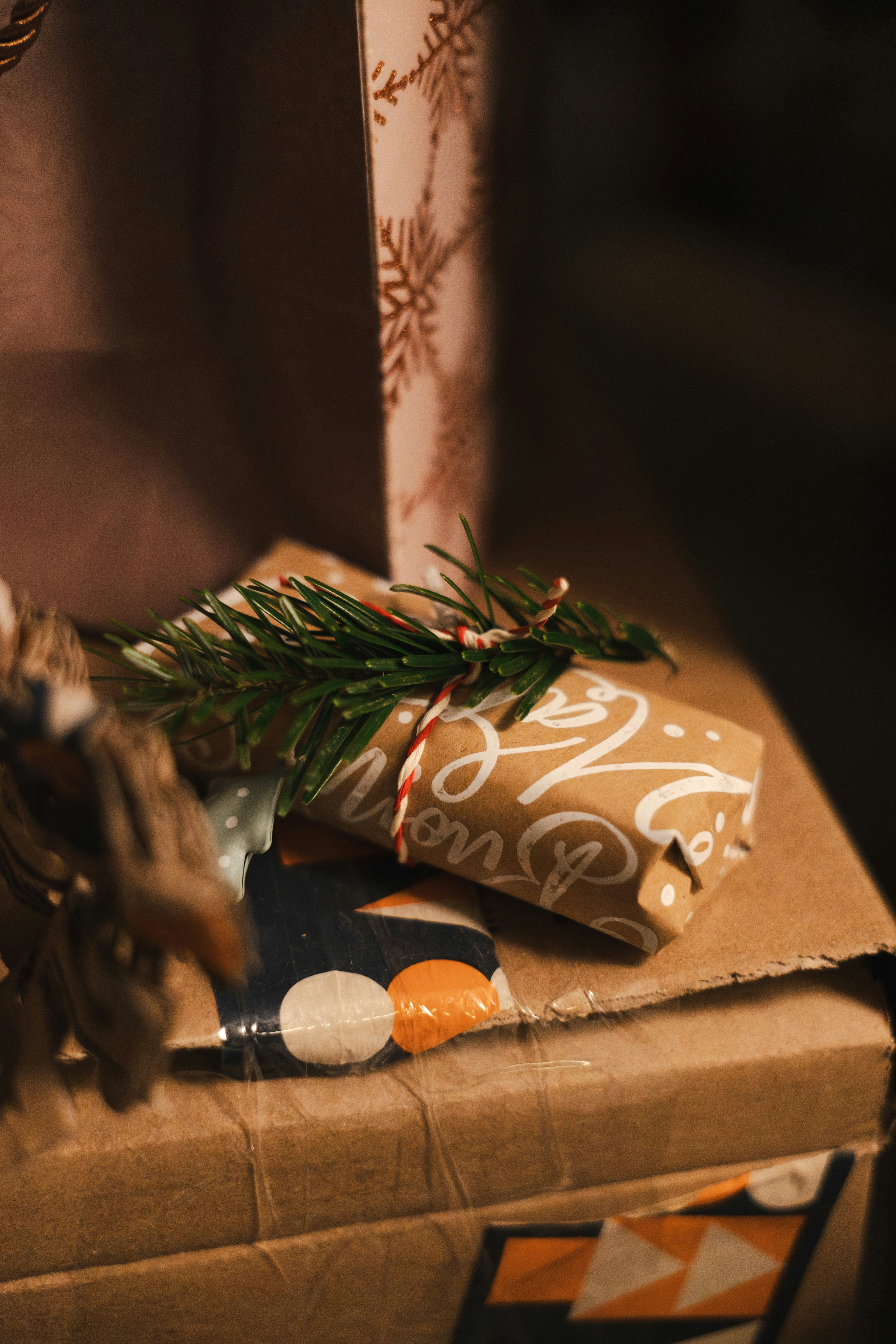 Christmas gifts wrapped in brown paper with pine sprigs.