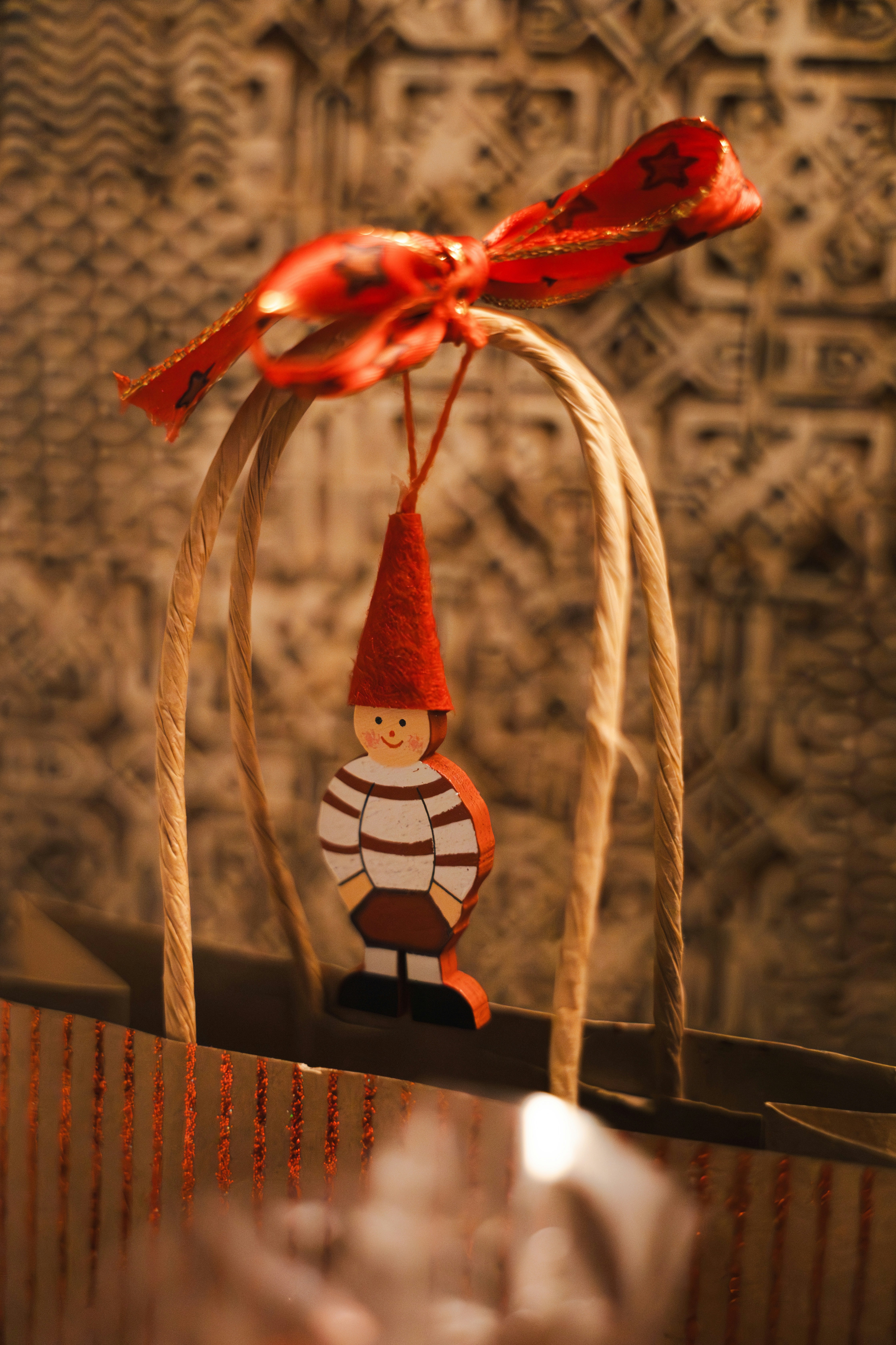 Ein Holzzwerg-Ornament hängt an einem Geschenkbeutelband