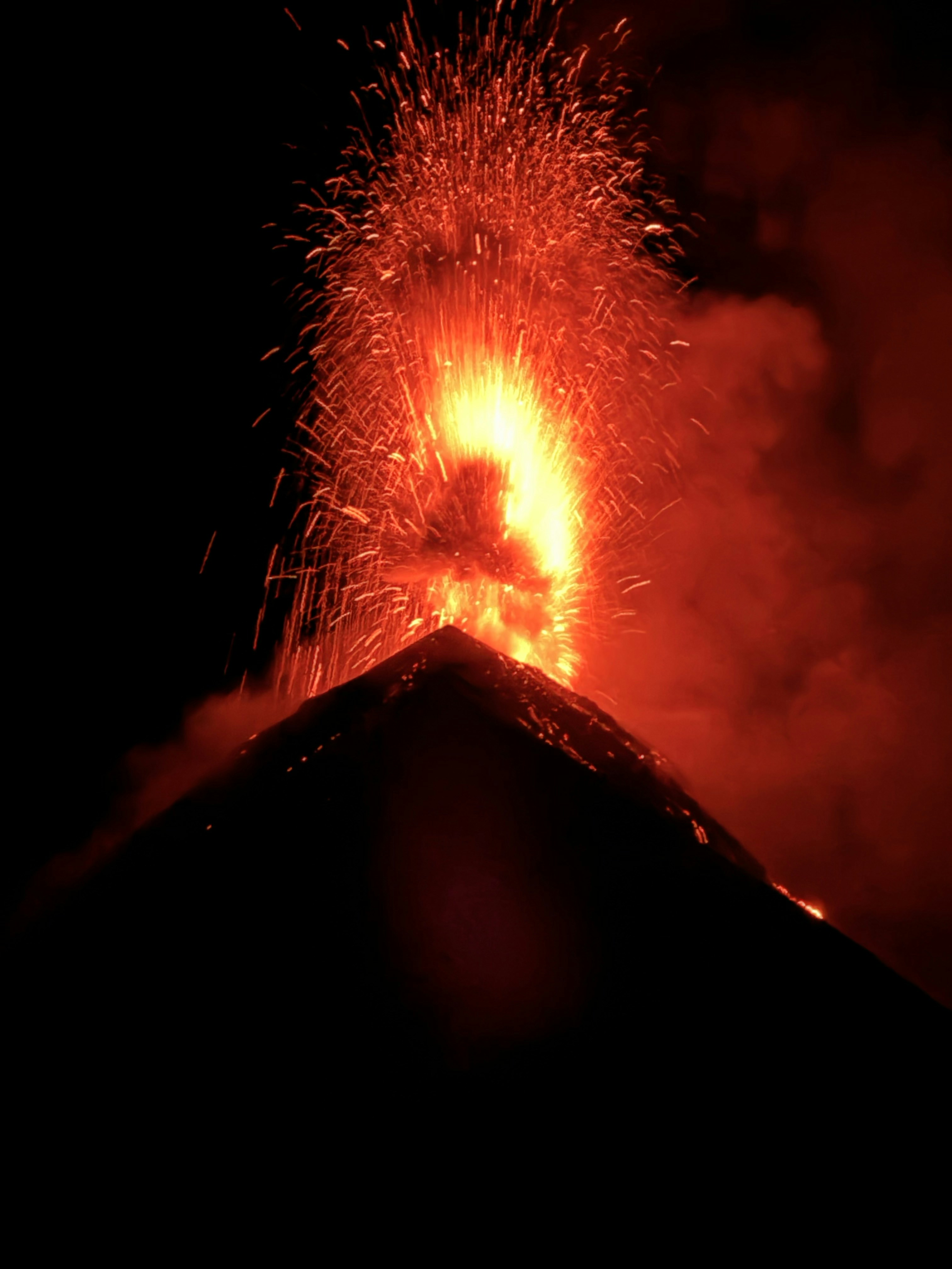 夜に火山が噴火し、溶岩と火花が散る