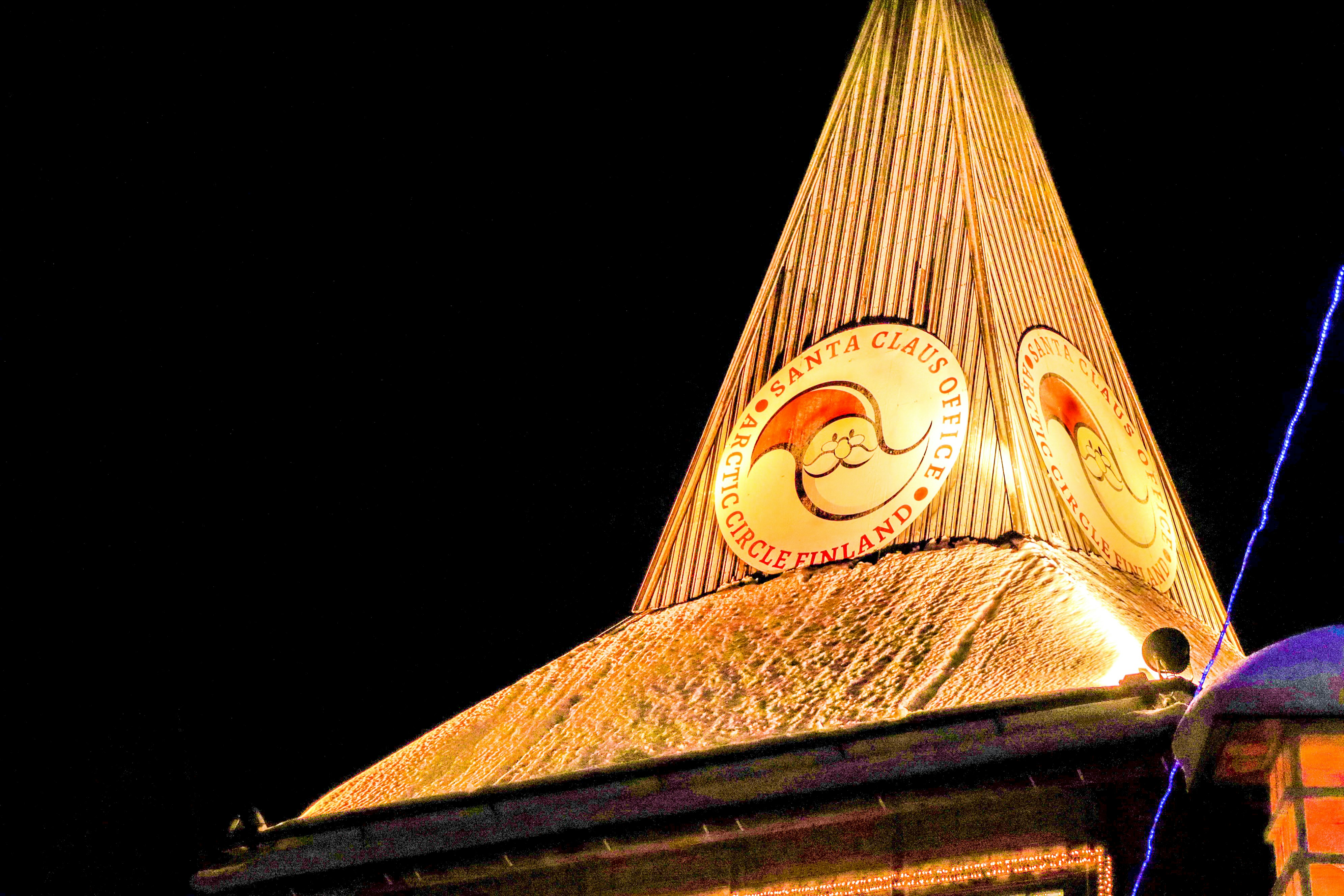 Golden spire with circular emblems at night