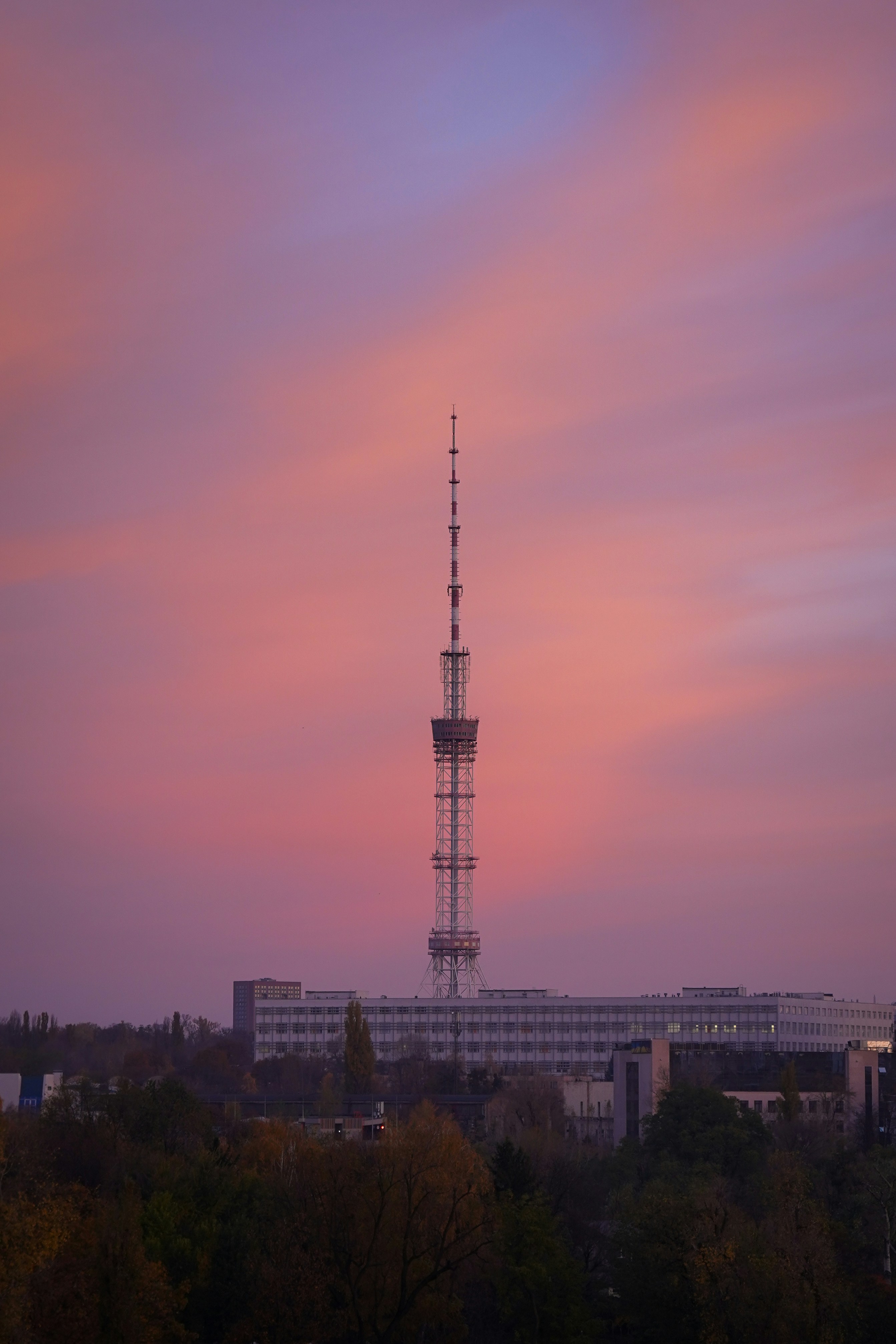 Tall tower against a pink and purple sunset sky.