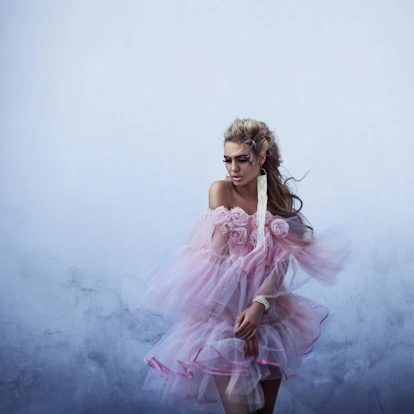 Woman in flowing pink dress with floral accents