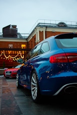 Two luxury cars parked outside a brick building