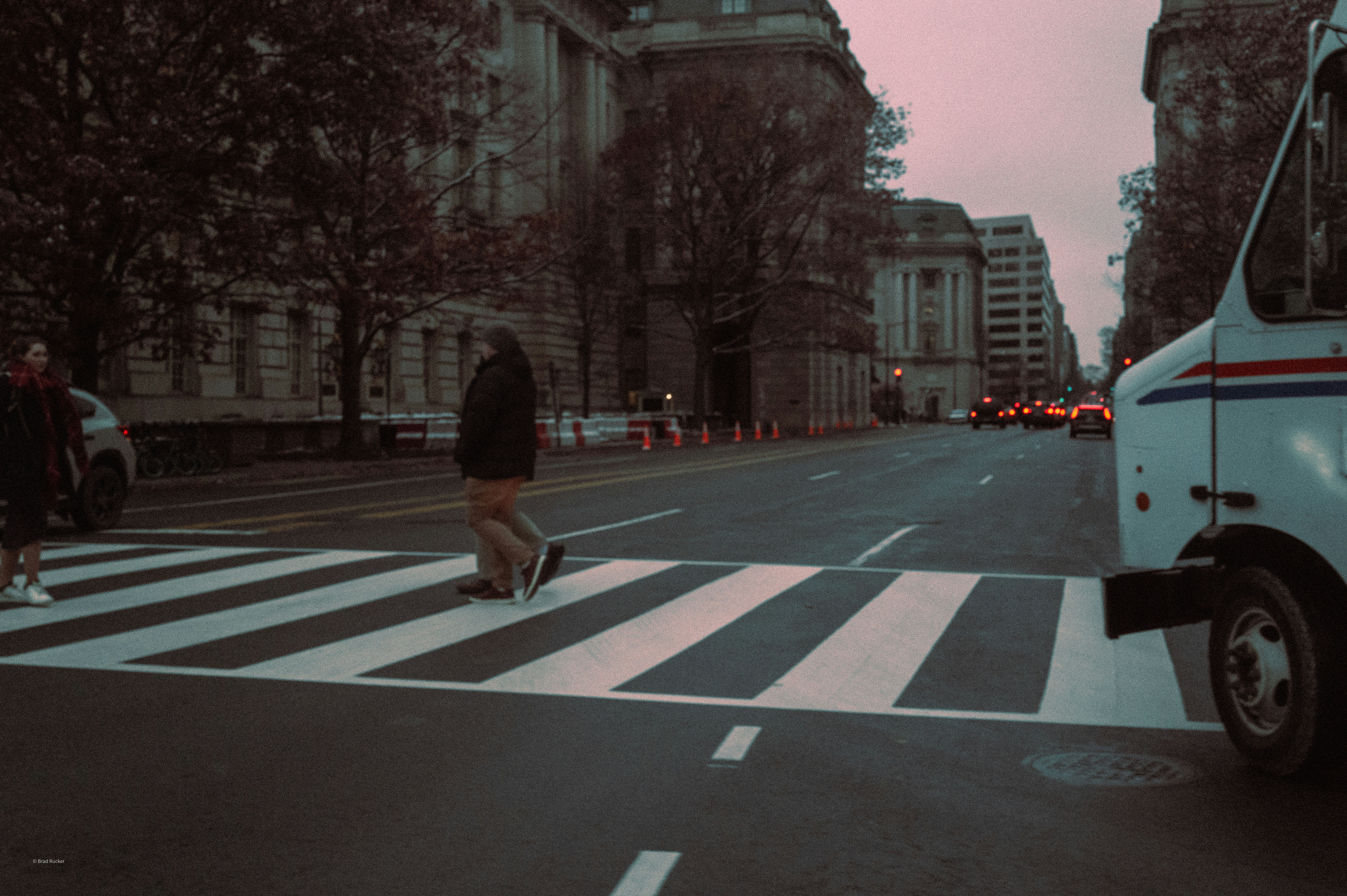 People crossing a street at a zebra crossing.