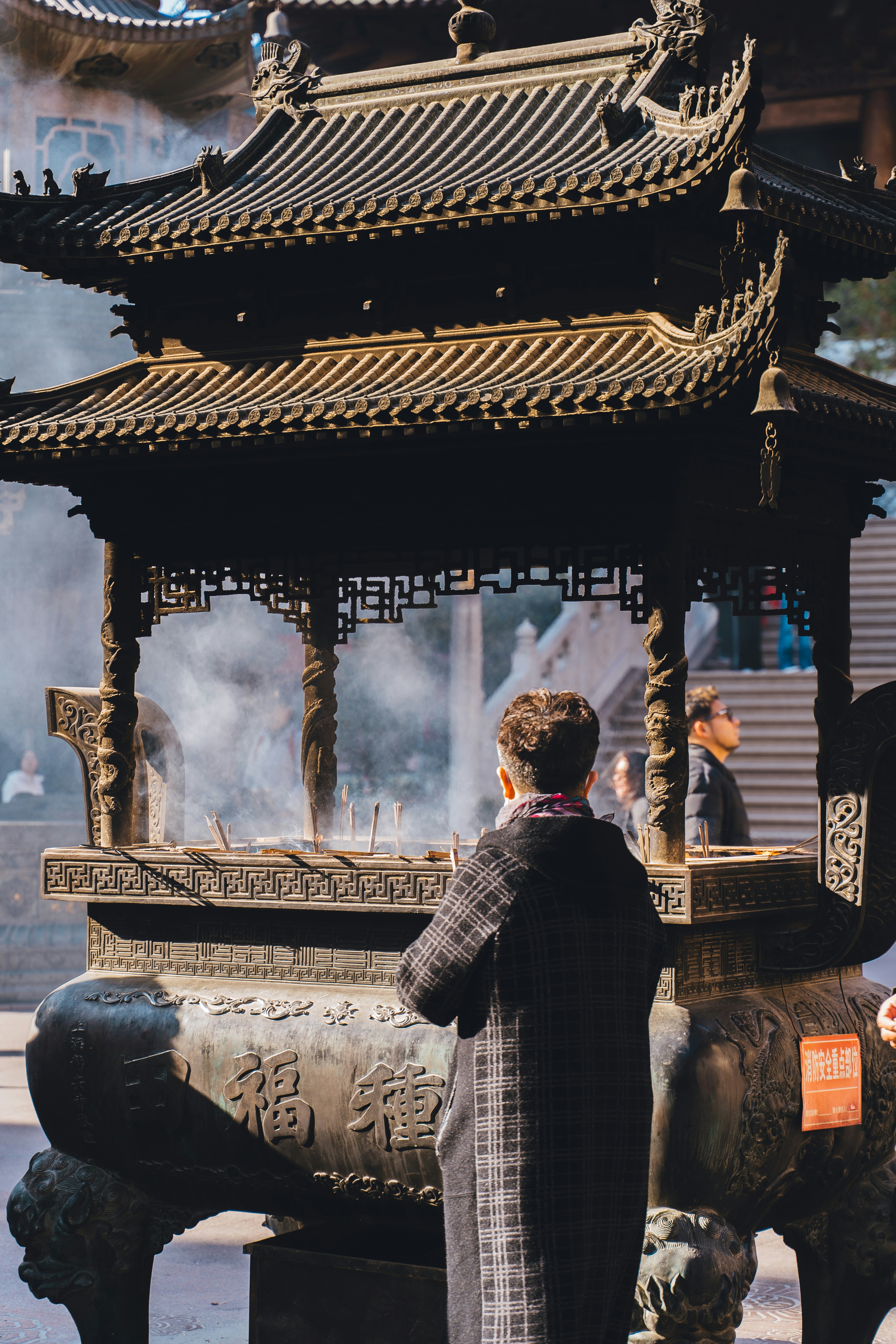 Person praying at a large incense burner