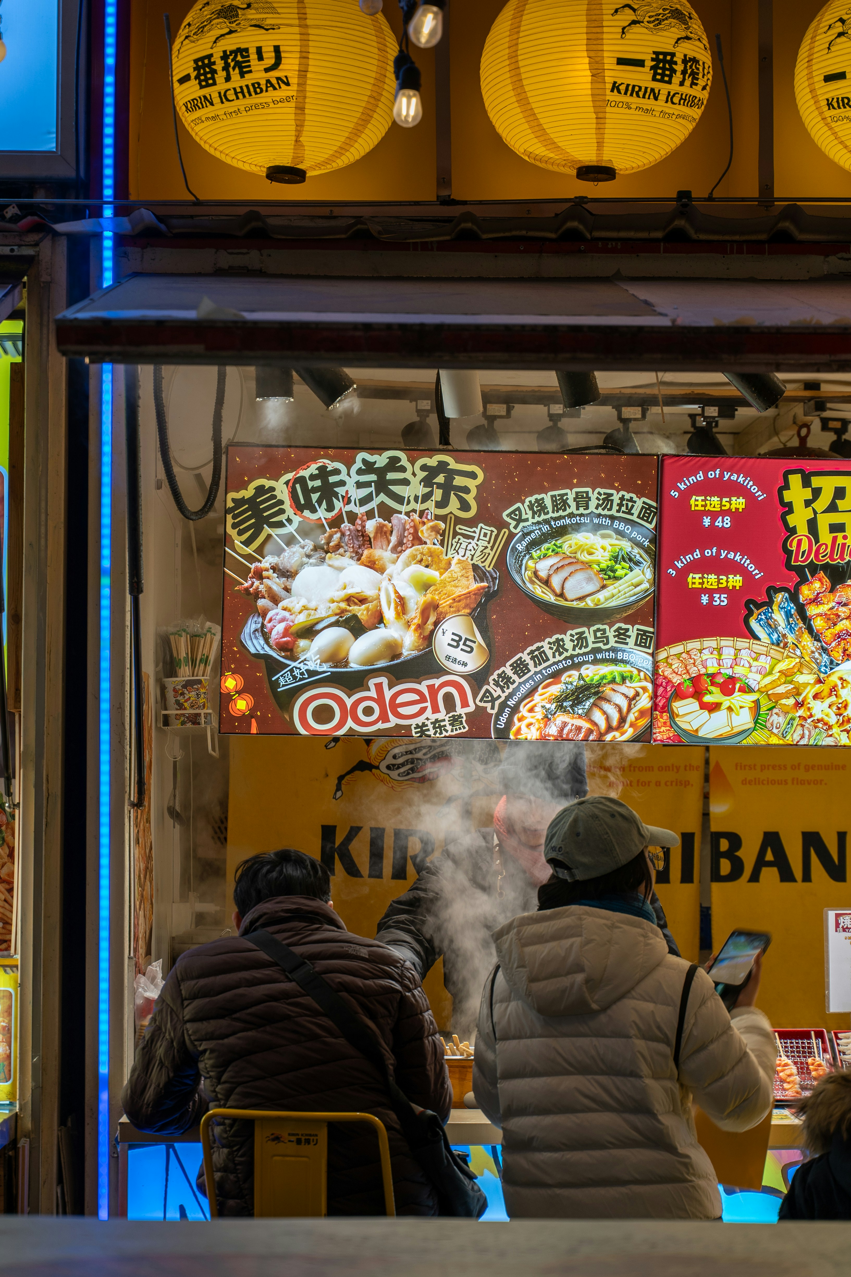 People eating at a japanese oden restaurant at night.