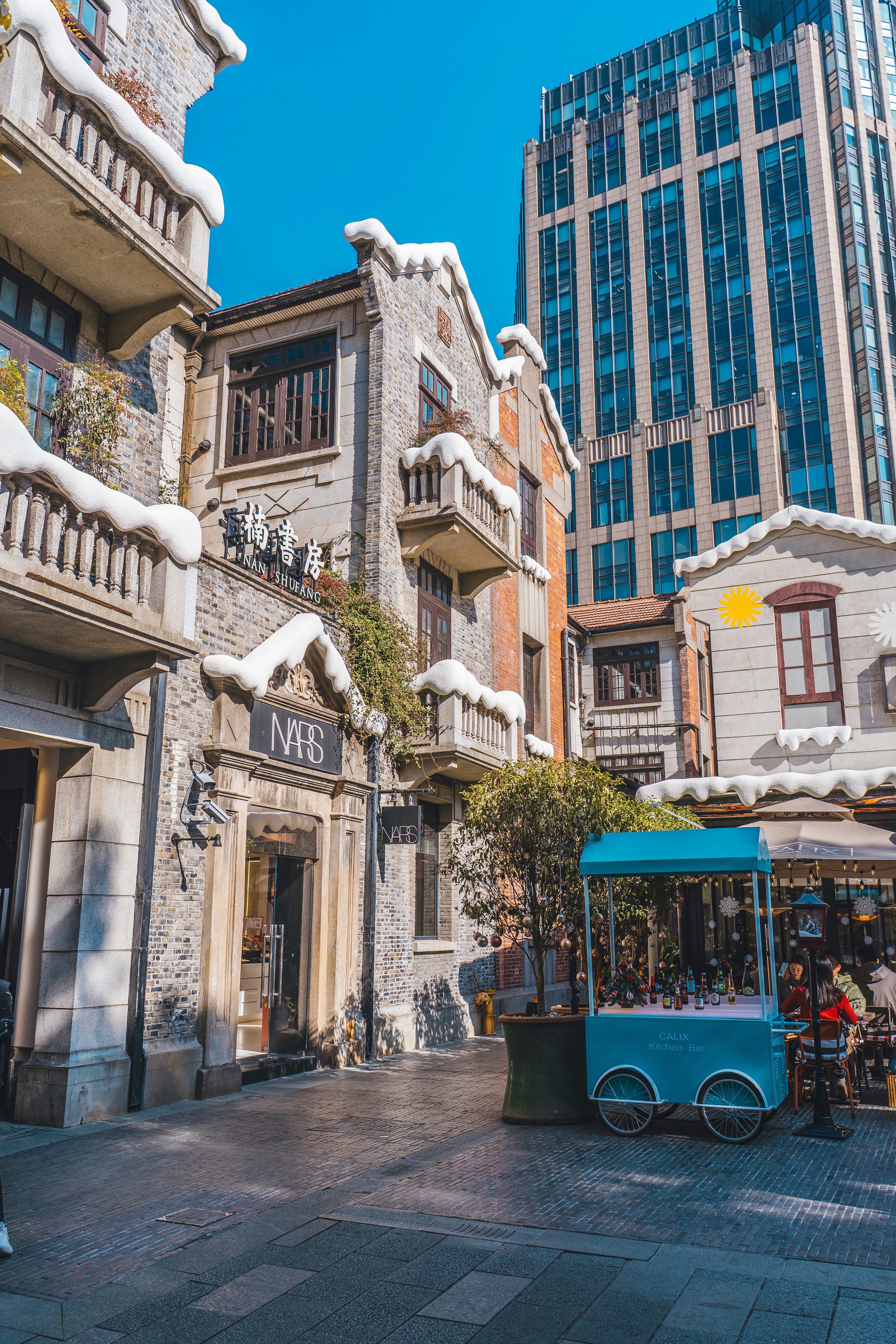 Snow-dusted buildings with a modern skyscraper behind.