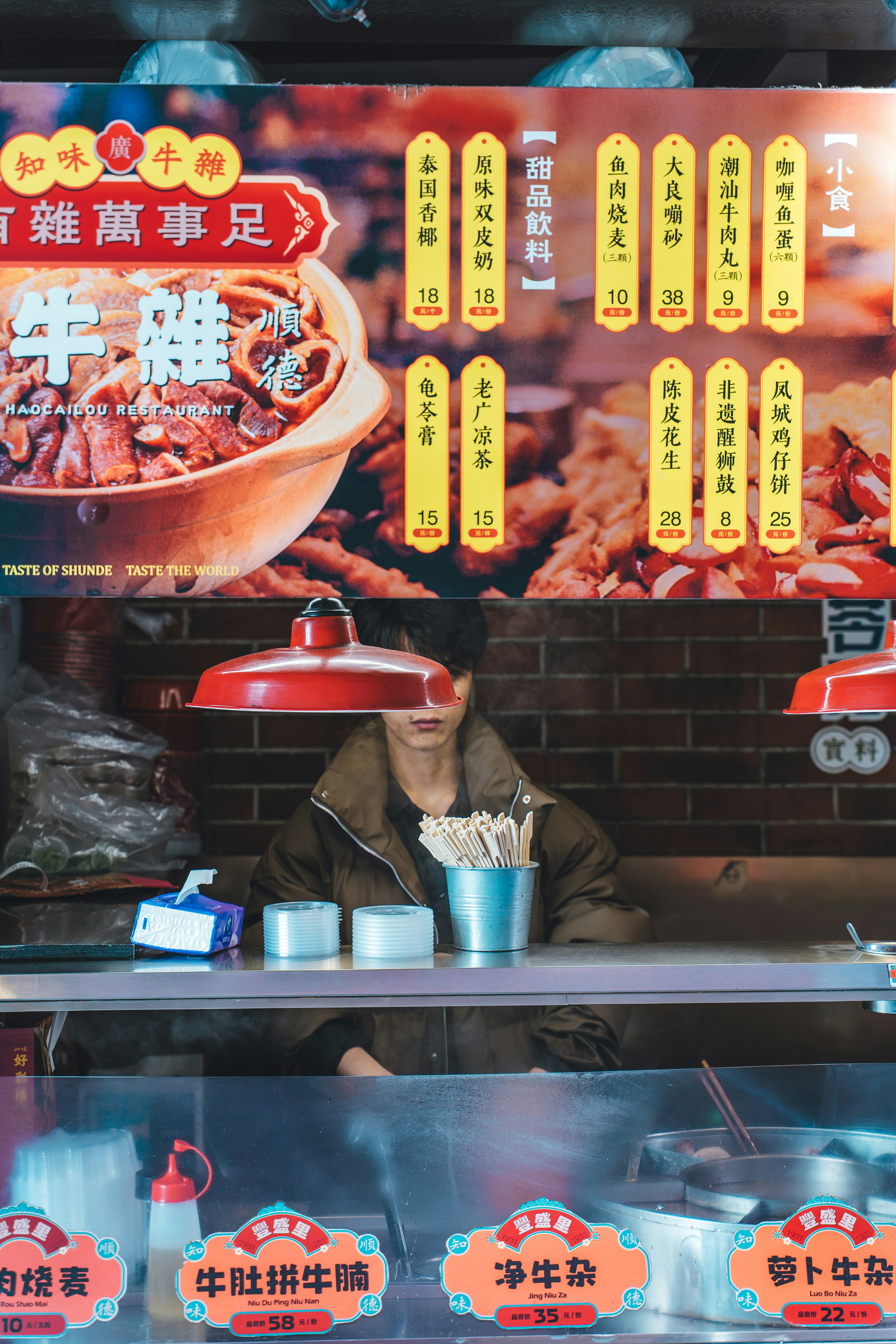 Vendor at food stall with menu board