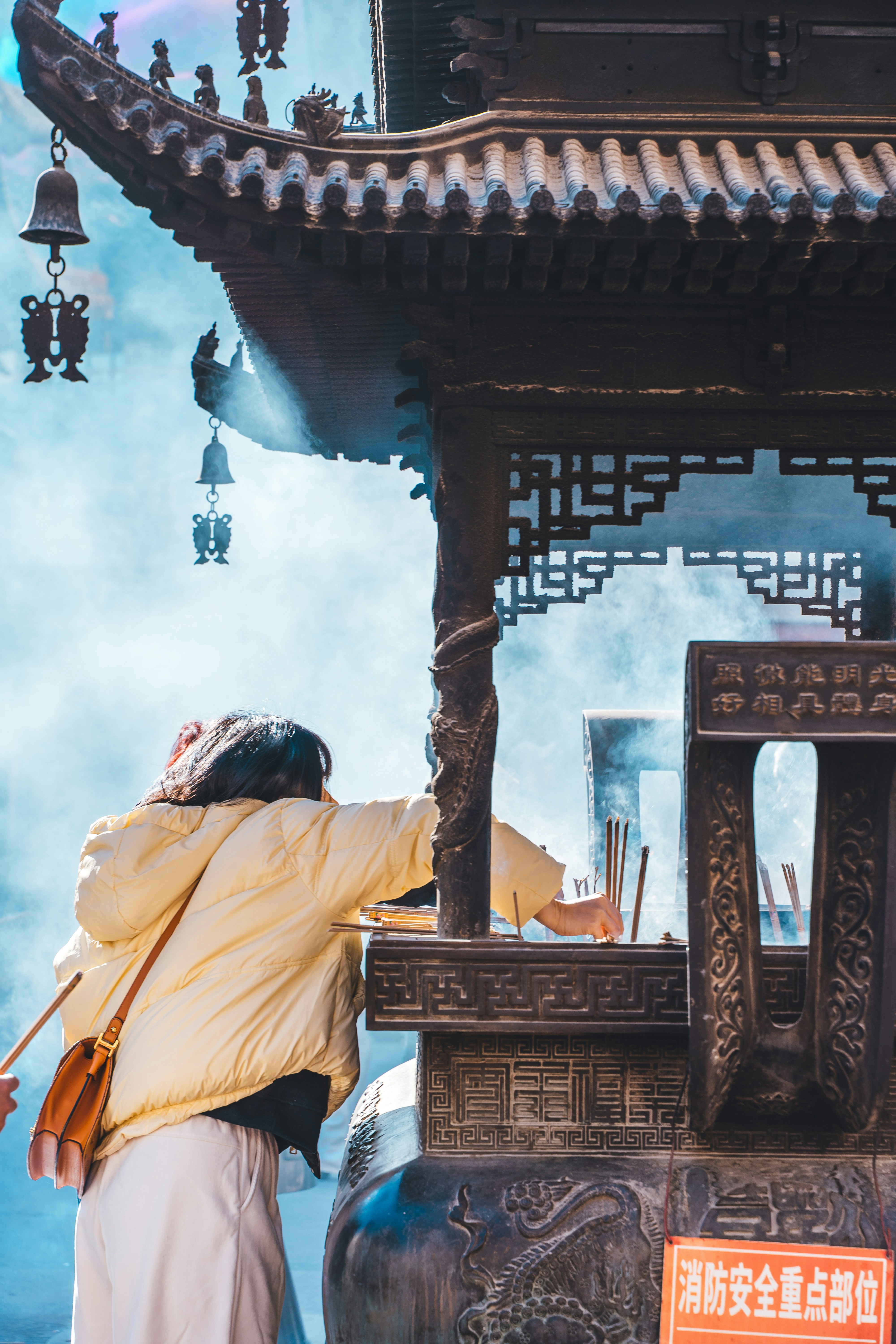 Woman lighting incense at a temple