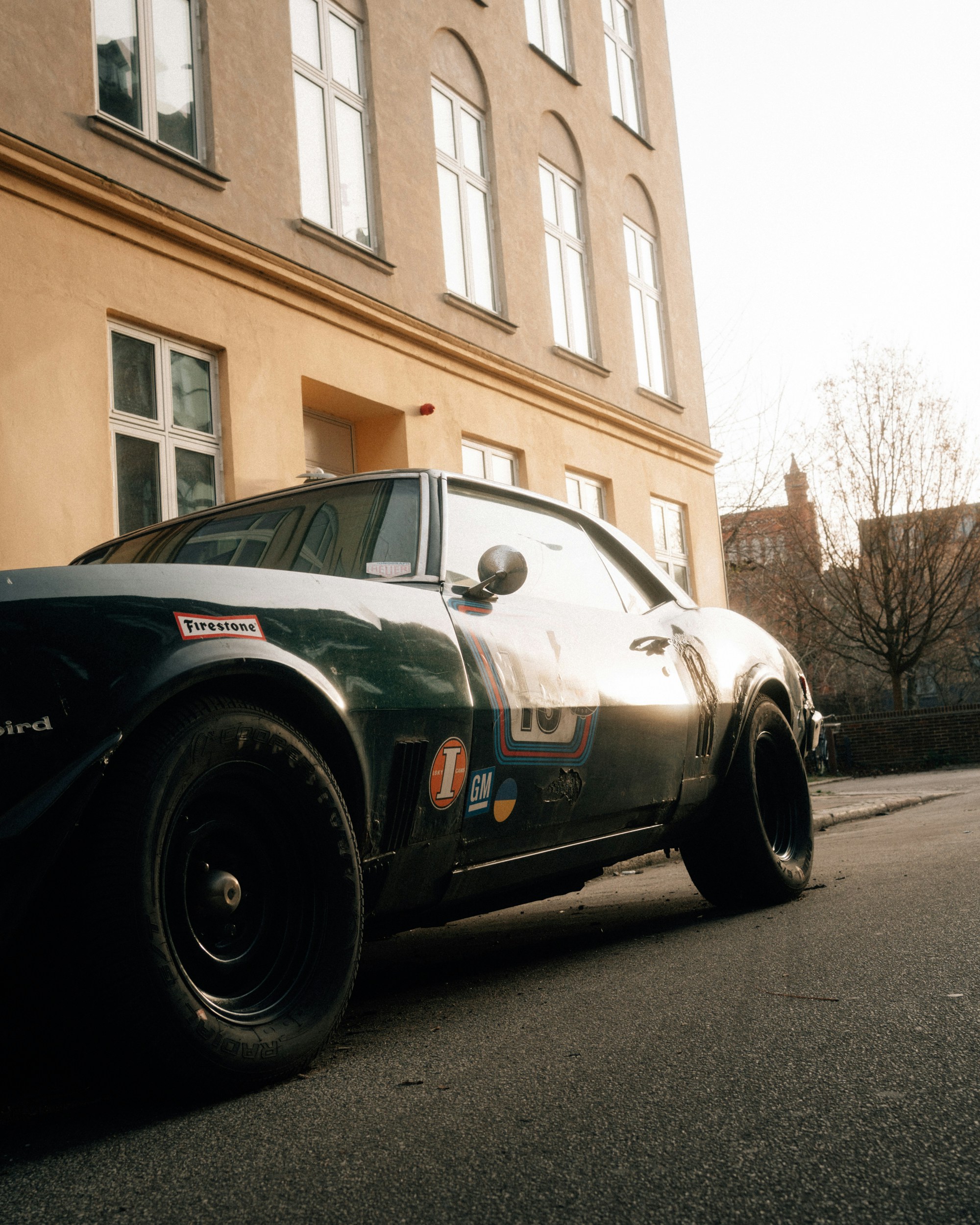 Classic dark green car parked on a street.