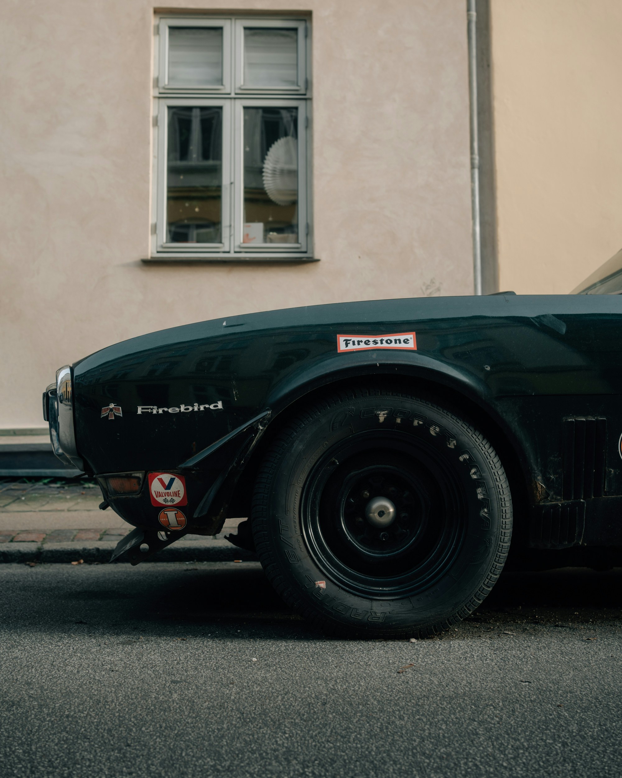 Vintage dark green firebird car with racing decals.