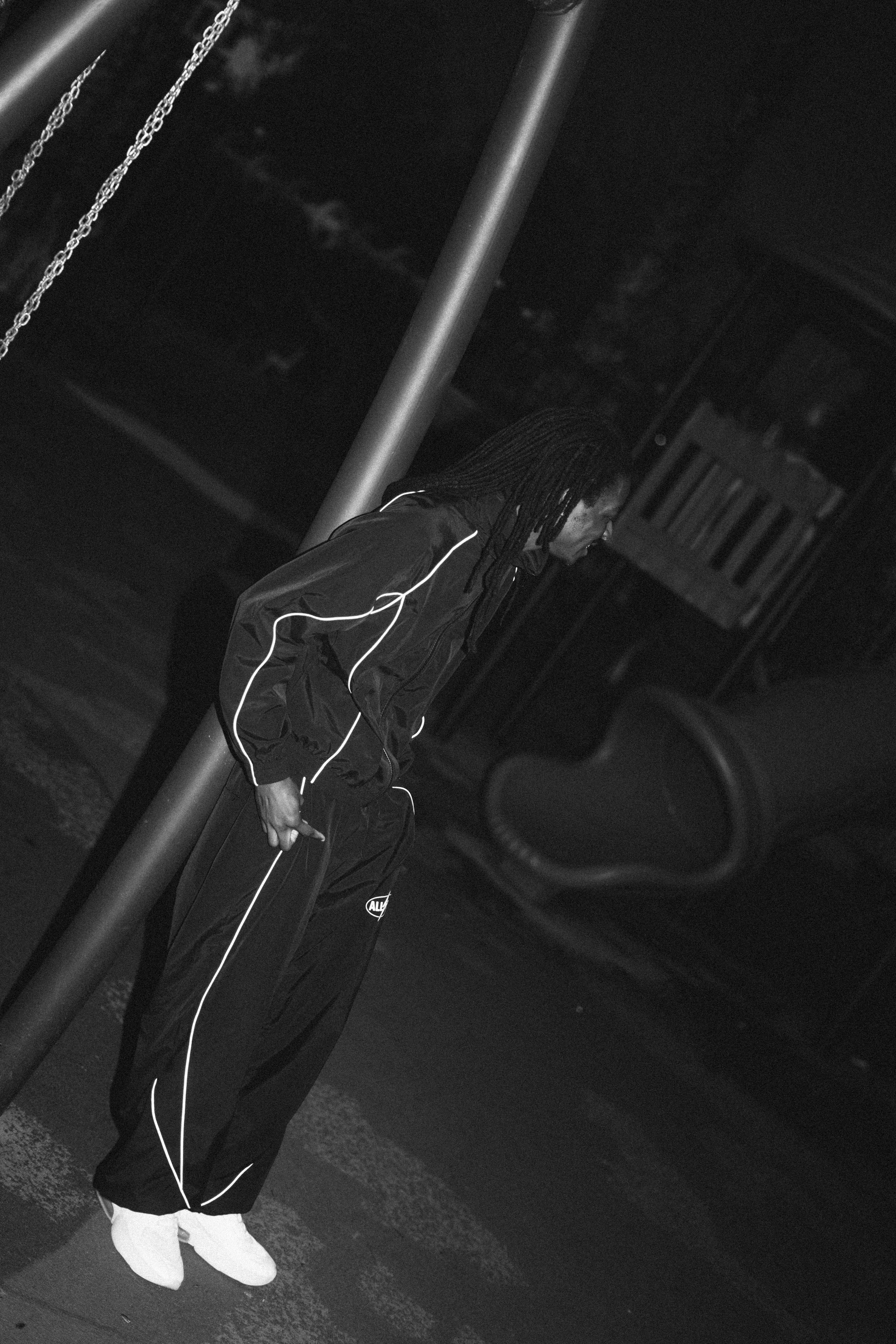 Man in tracksuit on playground at night