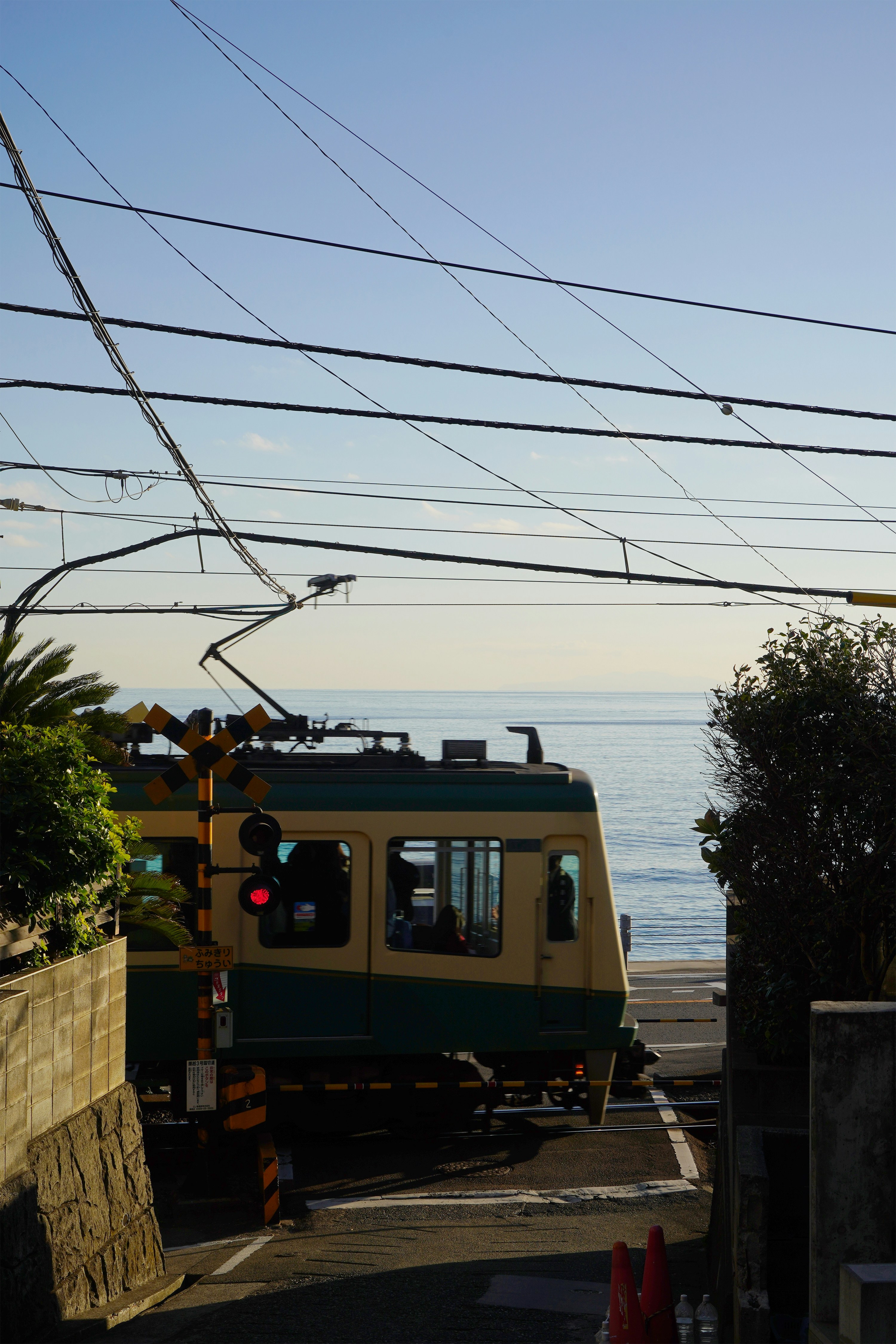 Train crossing tracks near the ocean.