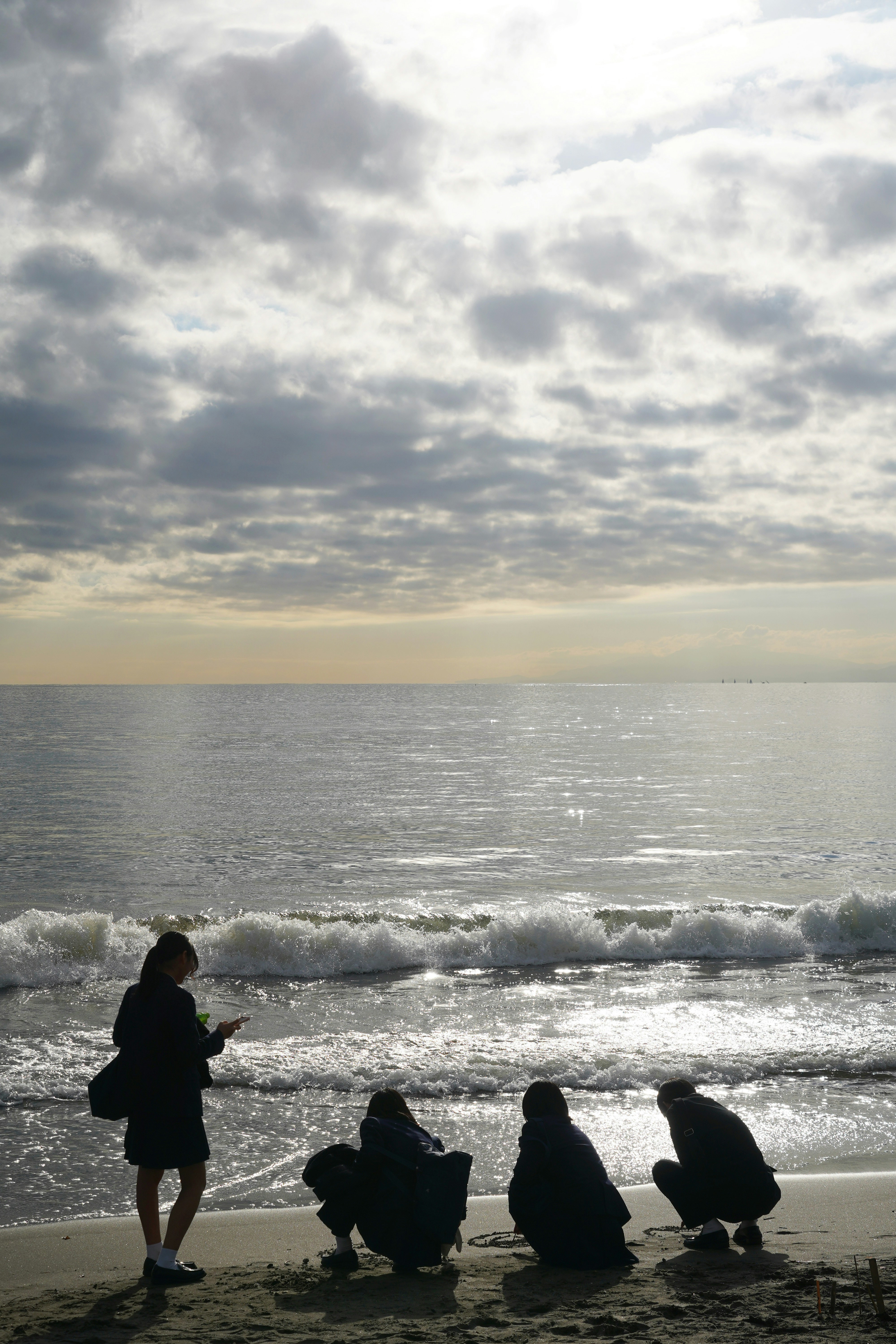 People on a beach watching the ocean waves