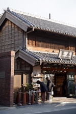 Two people browsing items outside a traditional japanese shop.