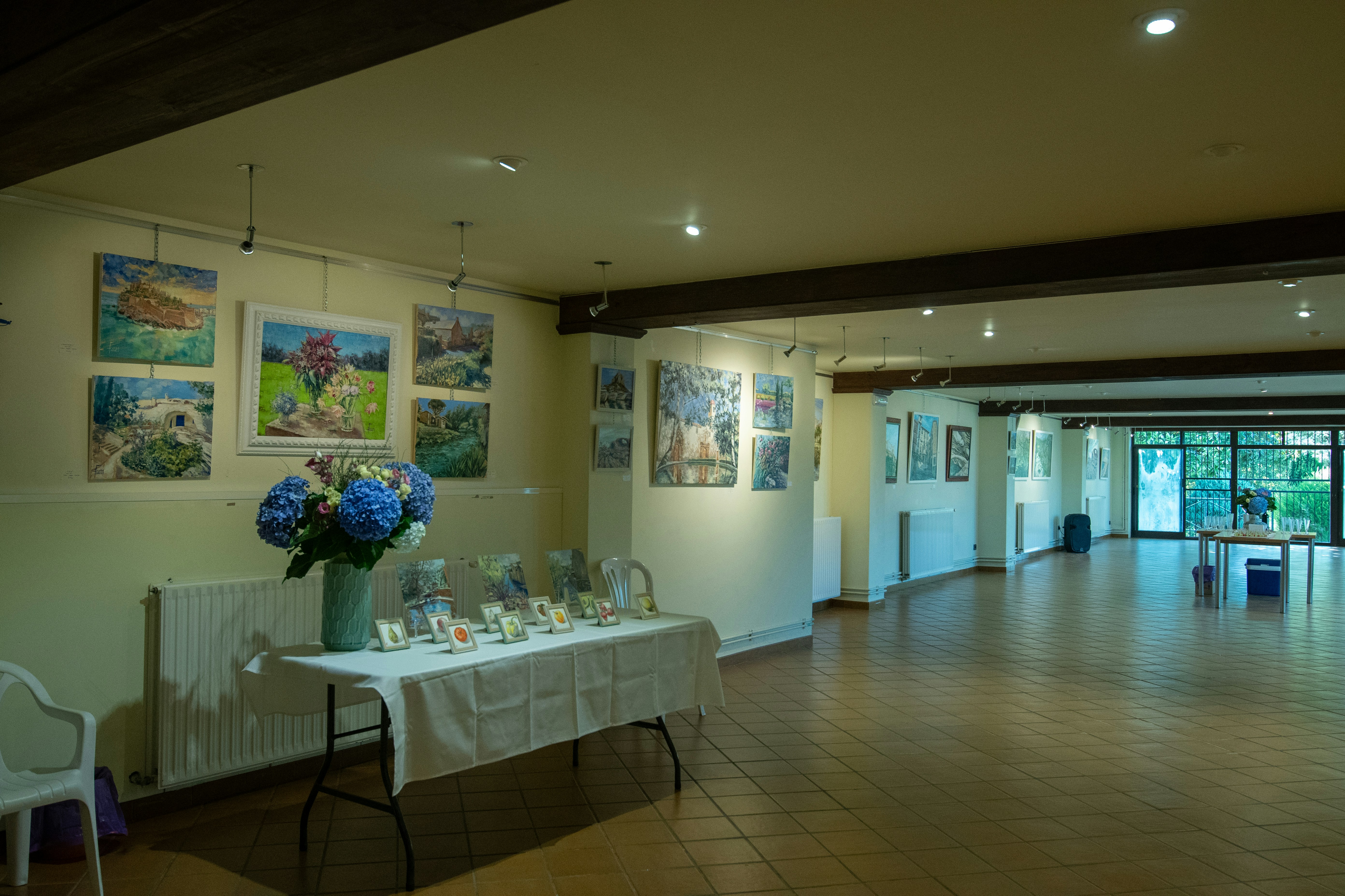 Art exhibition with paintings displayed on walls.
