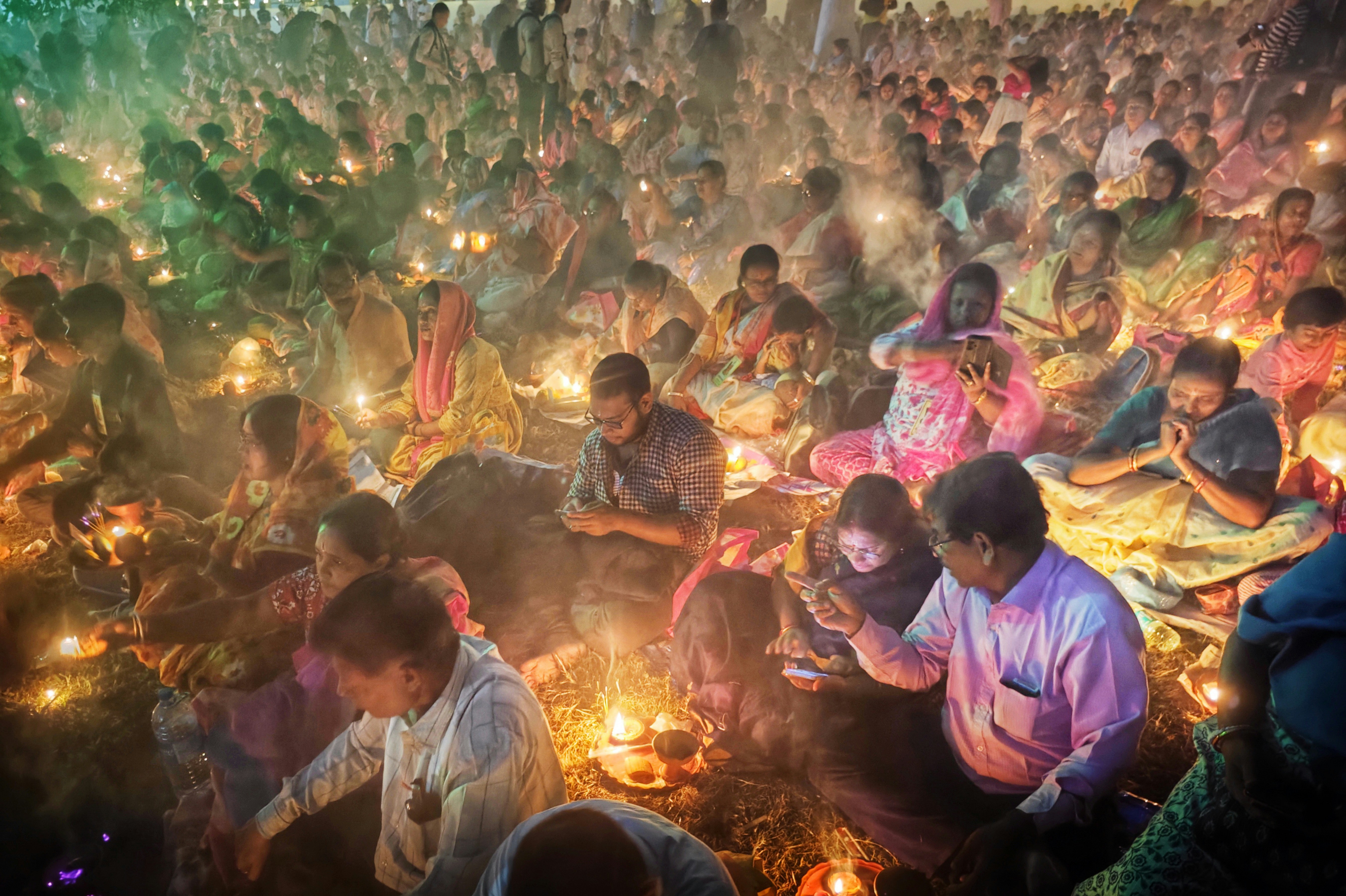 A large group of people gathered with lit candles