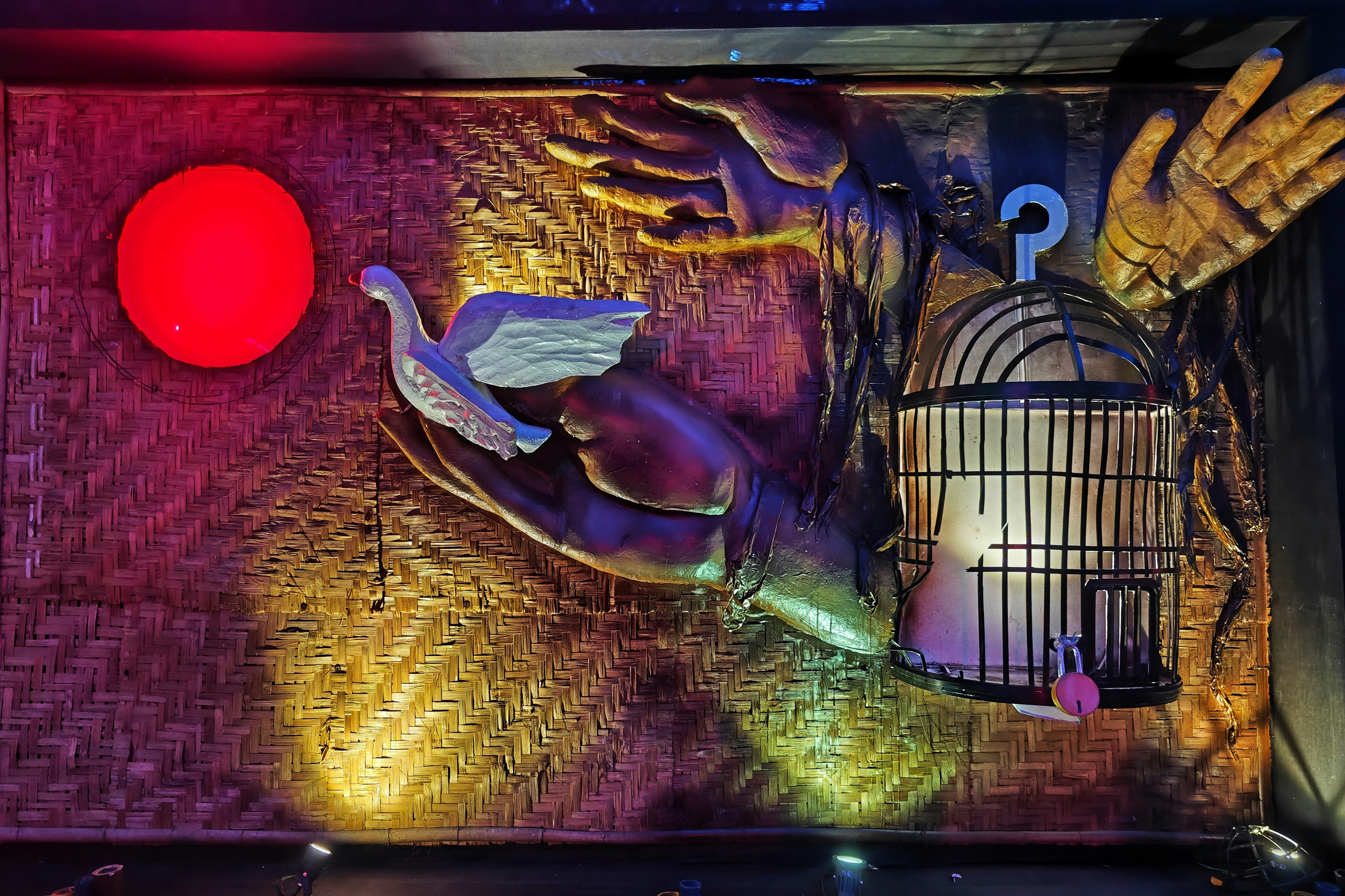 A bird in hands with a cage and red light