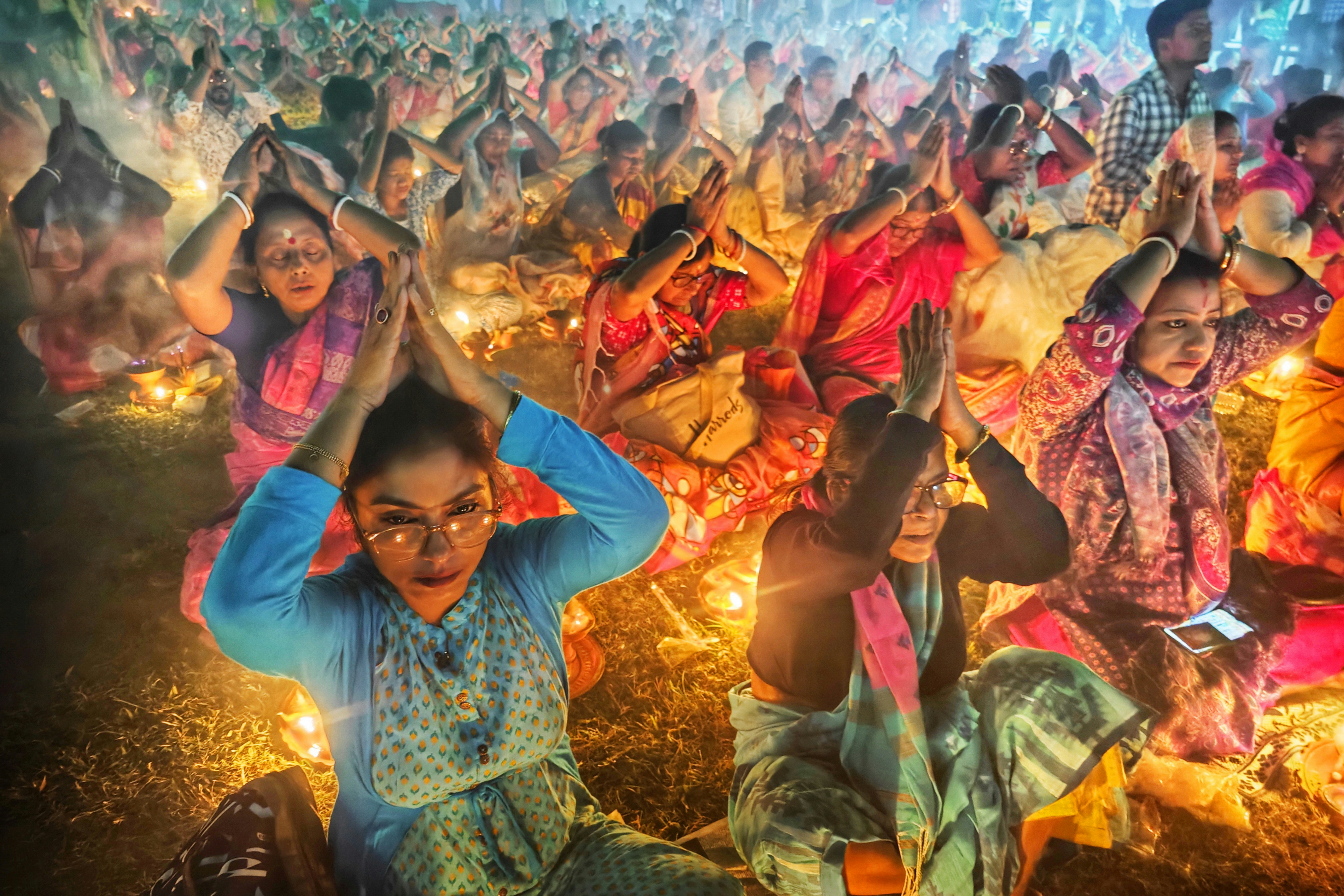 People praying with hands together during a festival
