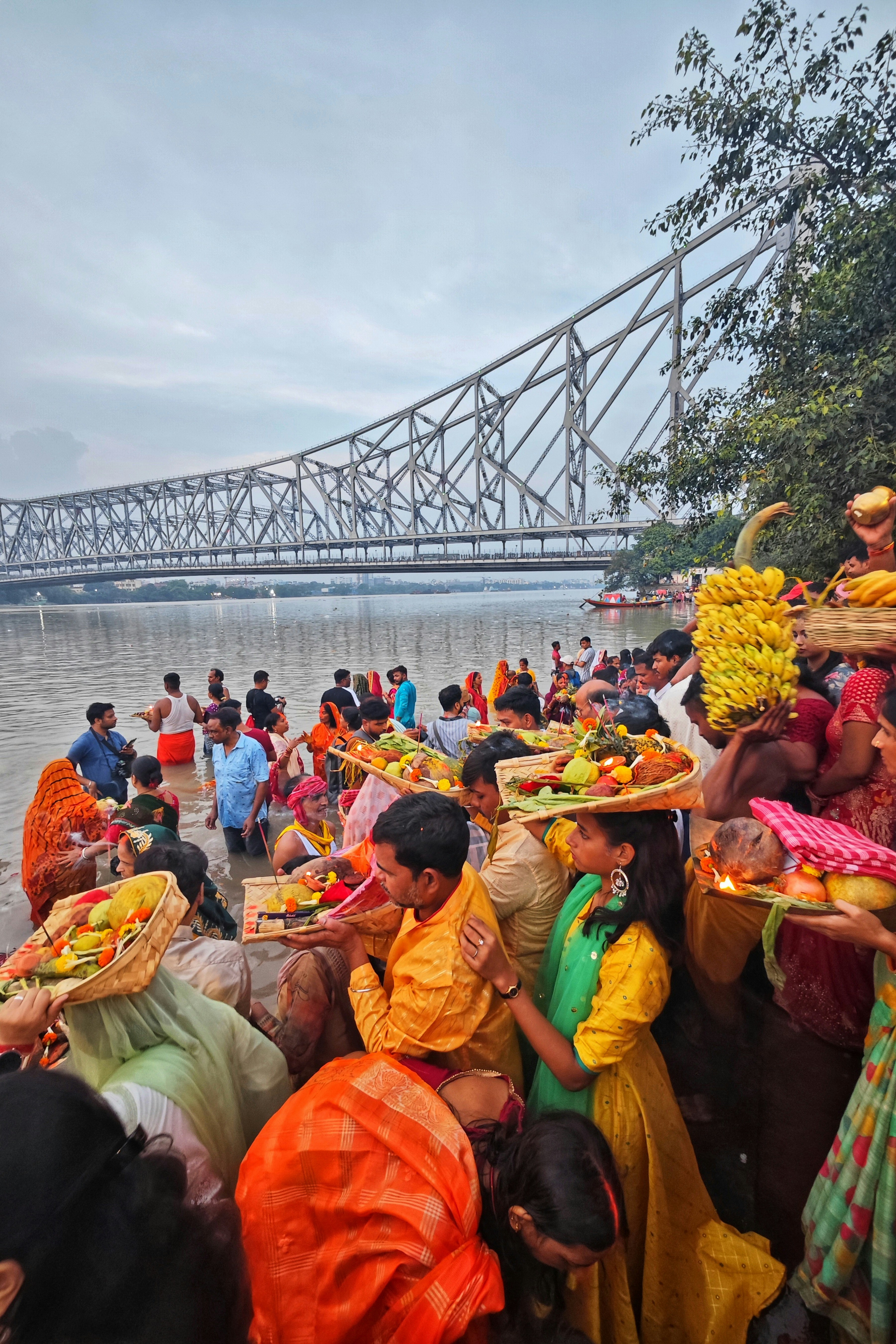 People offering prayers and fruits by a river