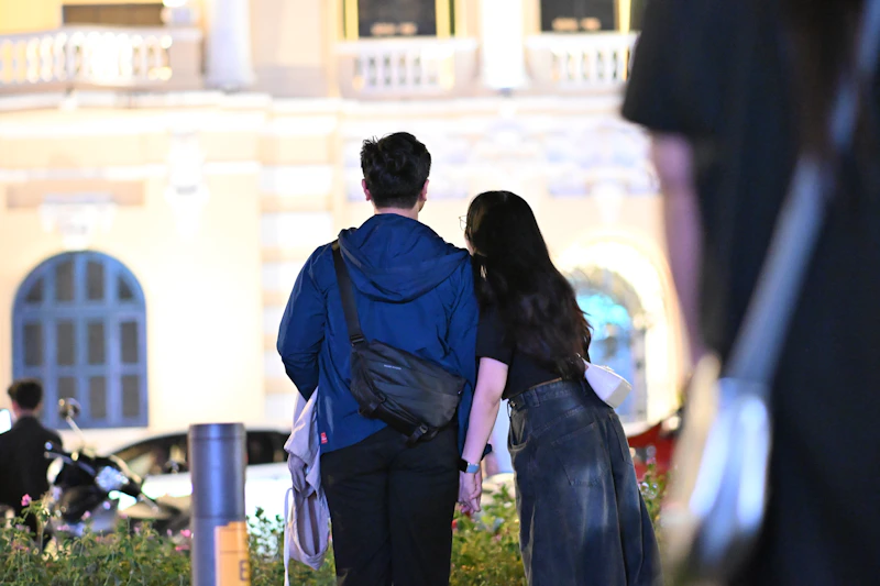 Couple holding hands with city buildings in background