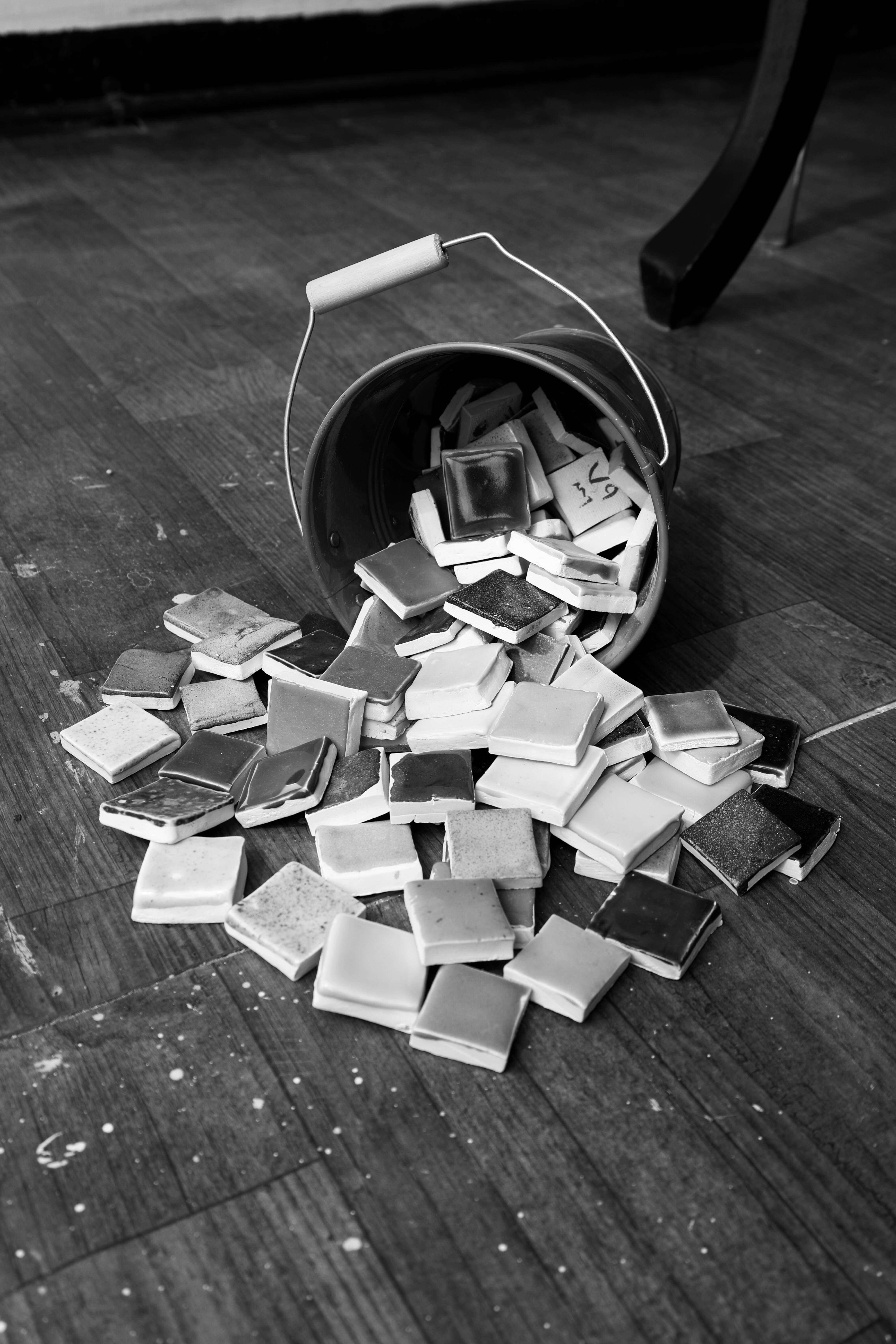 Bucket of tiles spilled on wooden floor