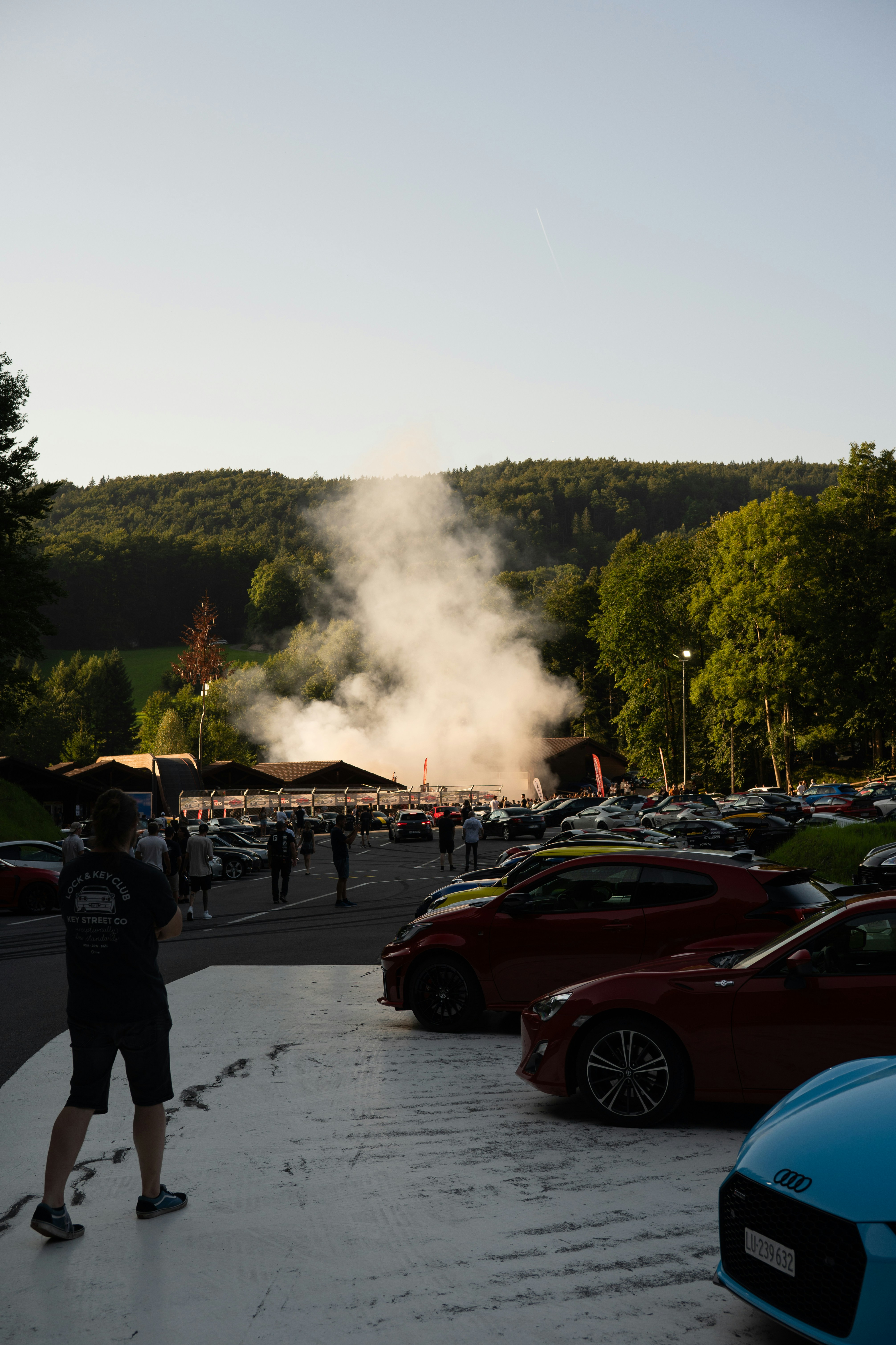 Cars gathered with smoke rising in background