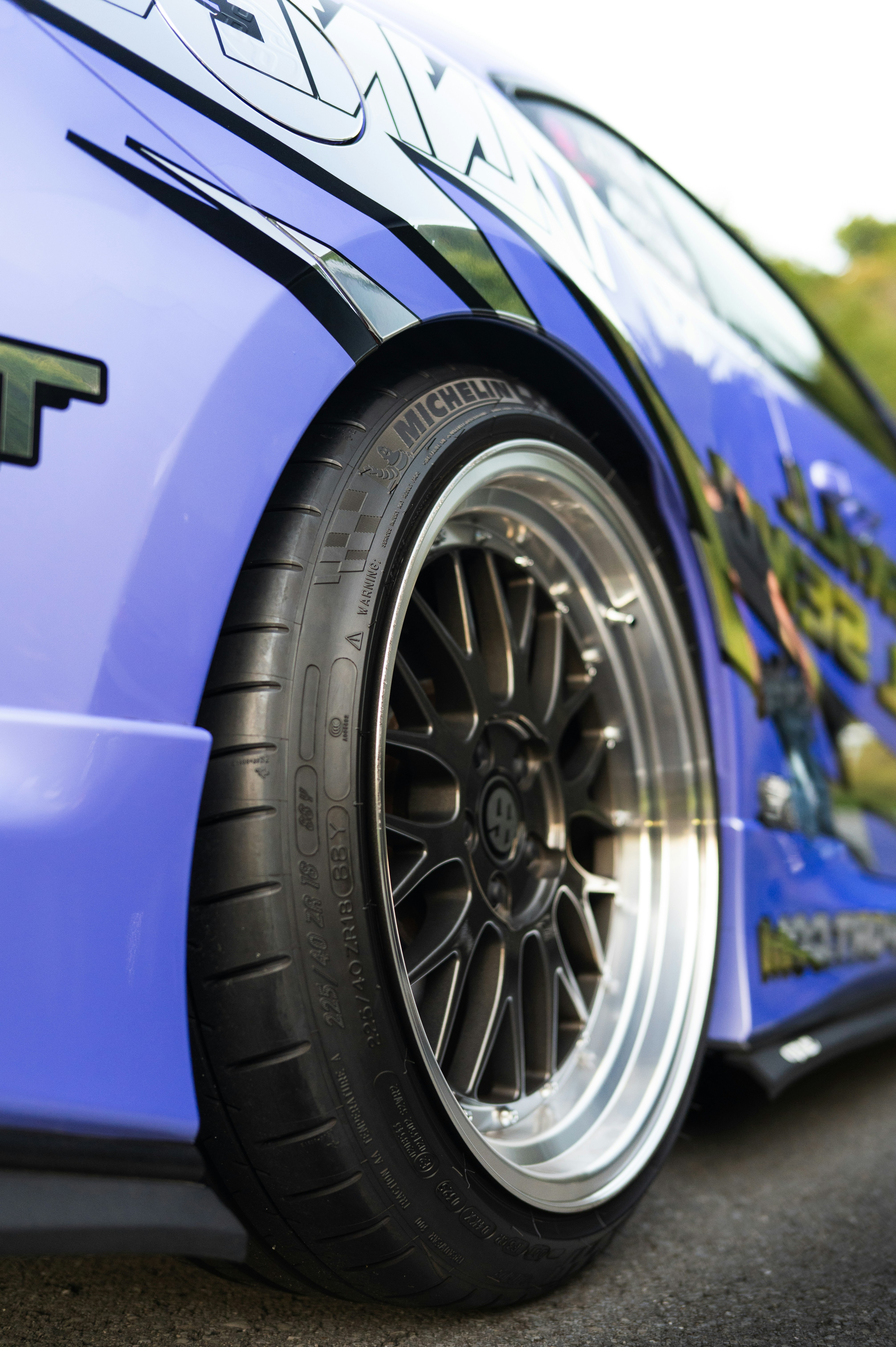 Close-up of a custom purple car wheel and tire.