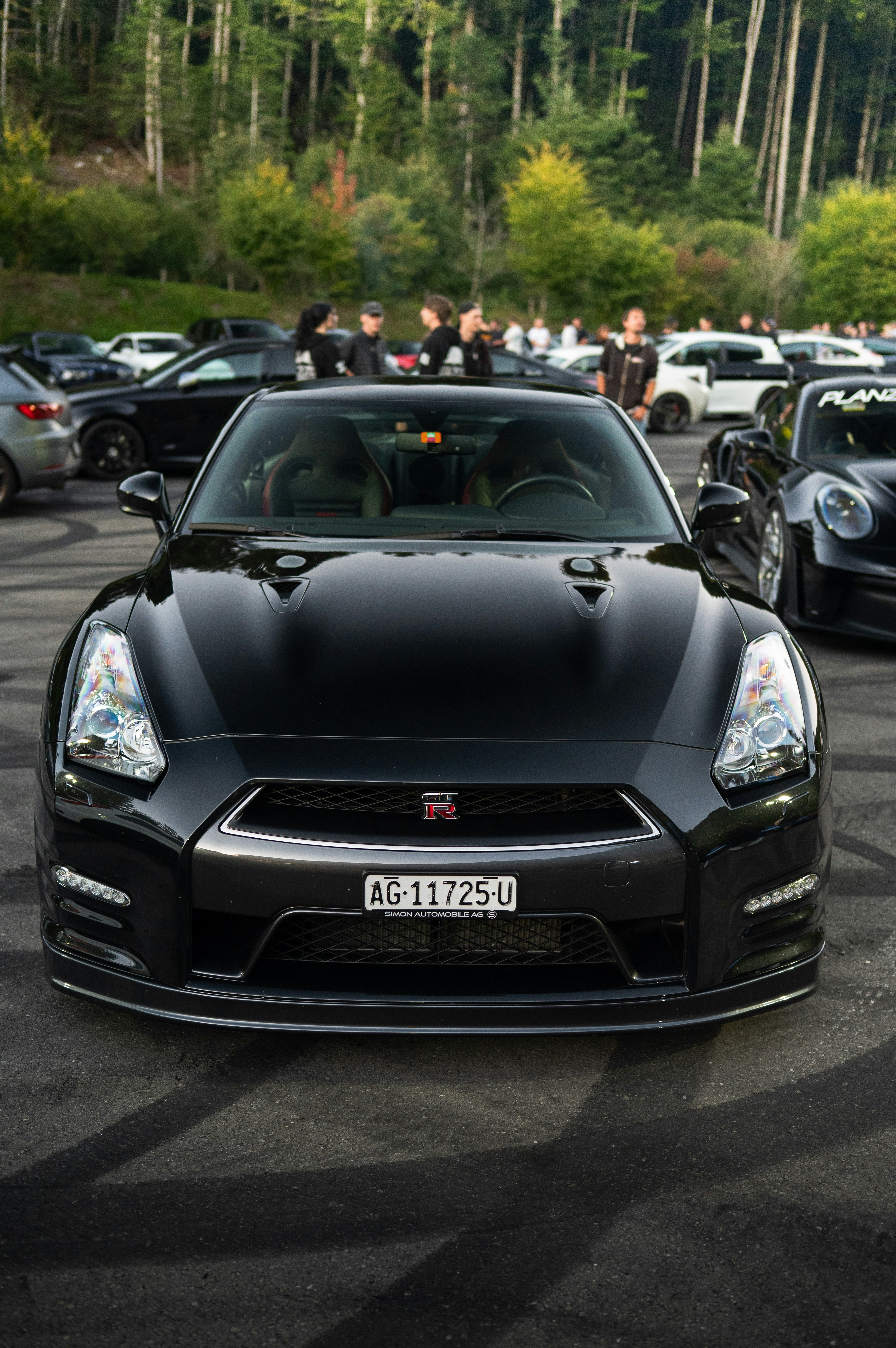 Black nissan gt-r parked outdoors with trees in background
