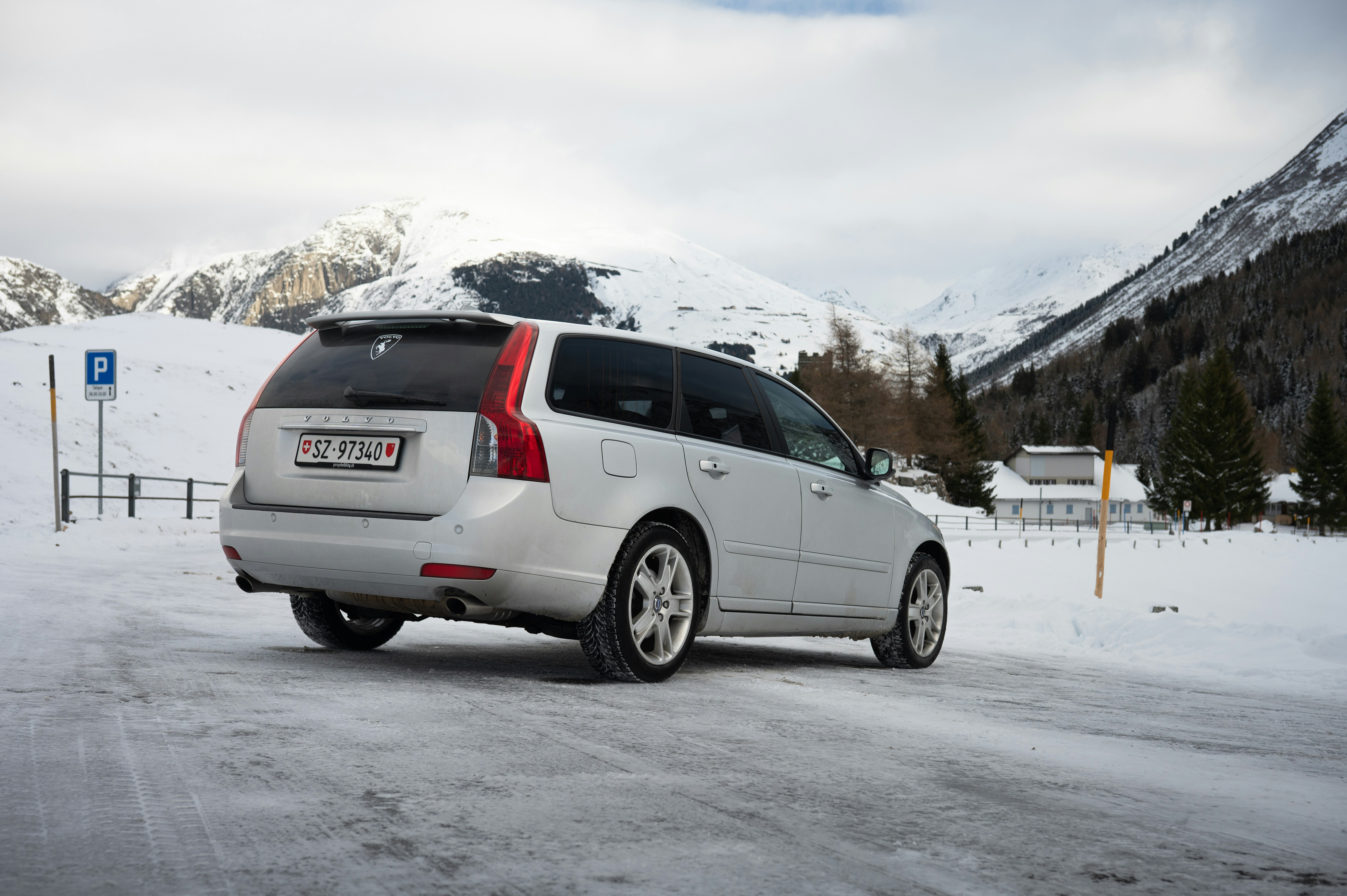 Silver volvo station wagon parked in snowy mountain landscape