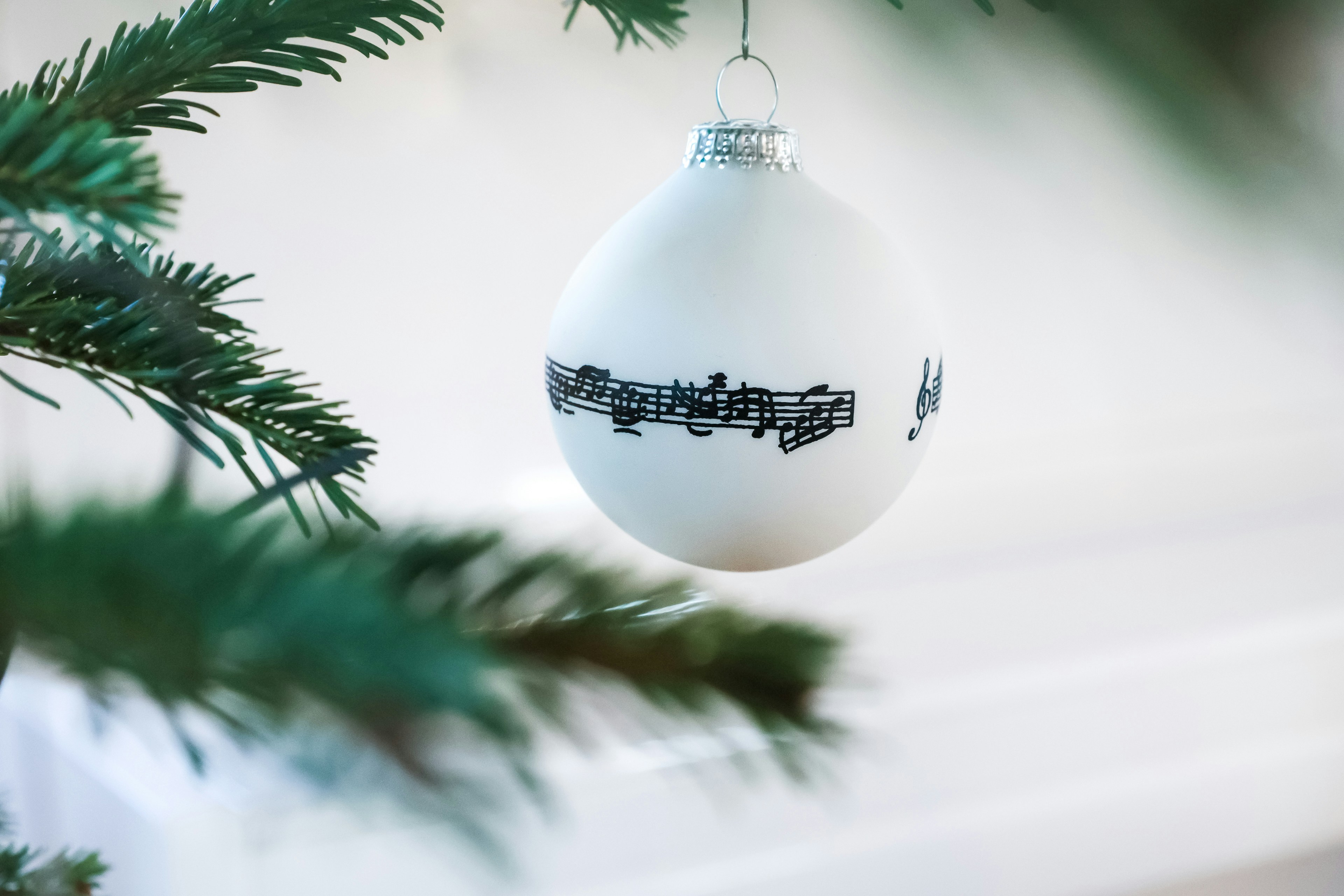 White ornament with musical notes on a tree