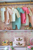 Baby clothes and shoes neatly organized on shelves.