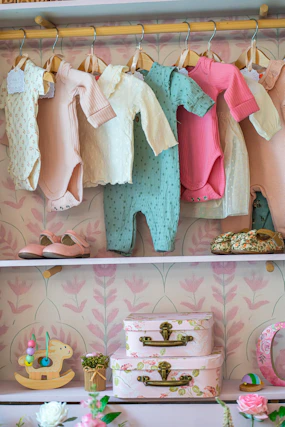 Baby clothes and shoes neatly organized on shelves.