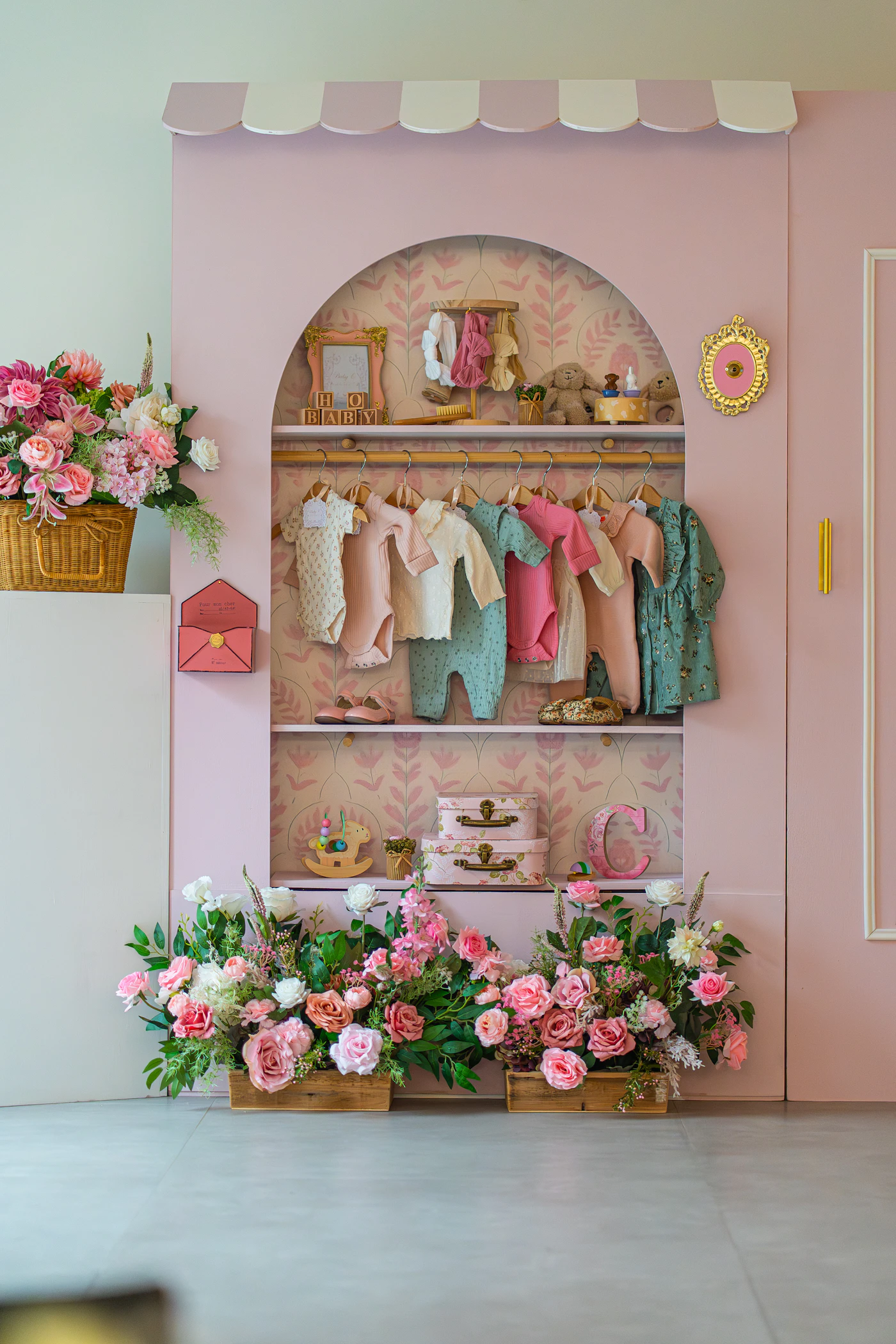 Pink wardrobe with handmade baby clothes and flowers