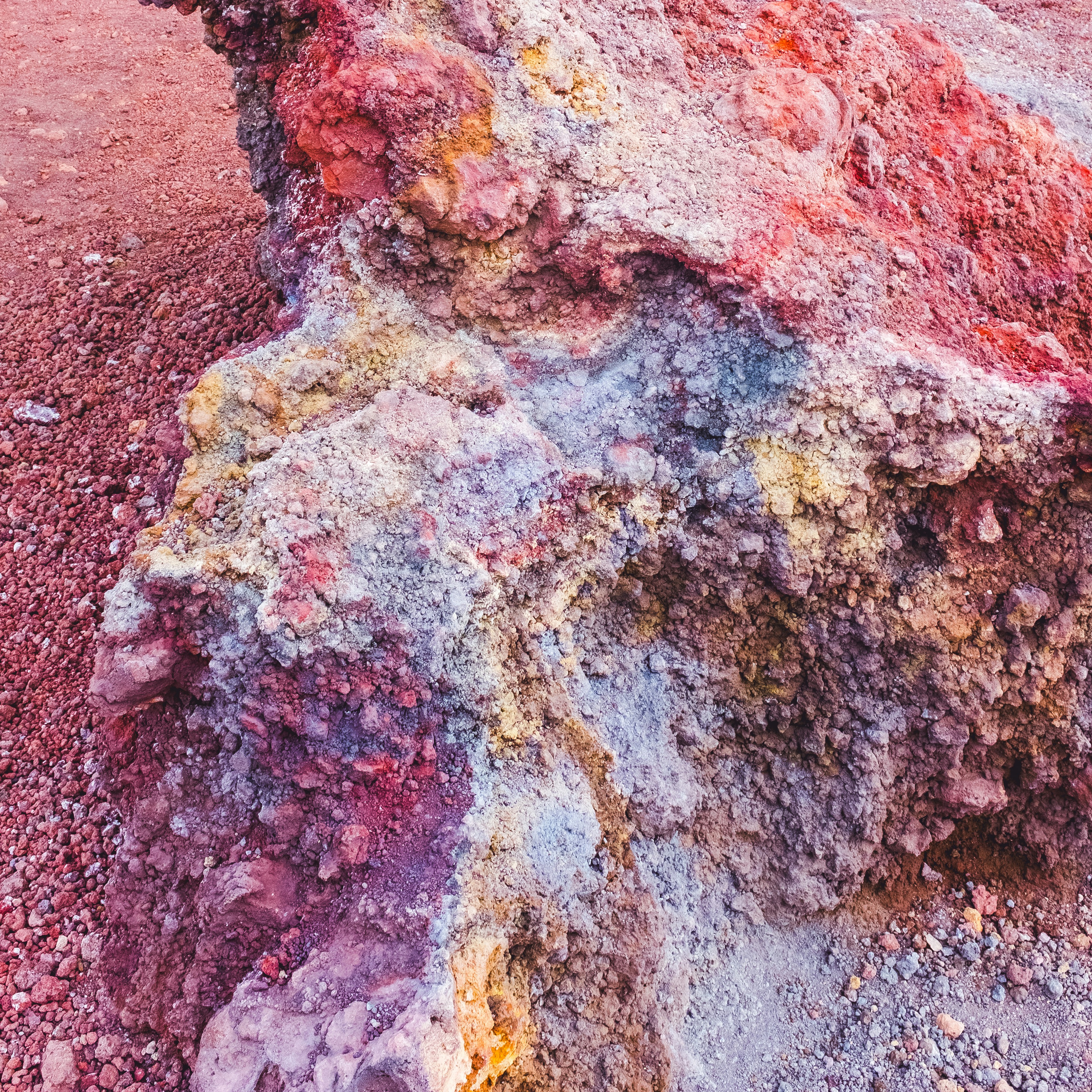 Colorful volcanic rock with red, yellow, and blue hues.