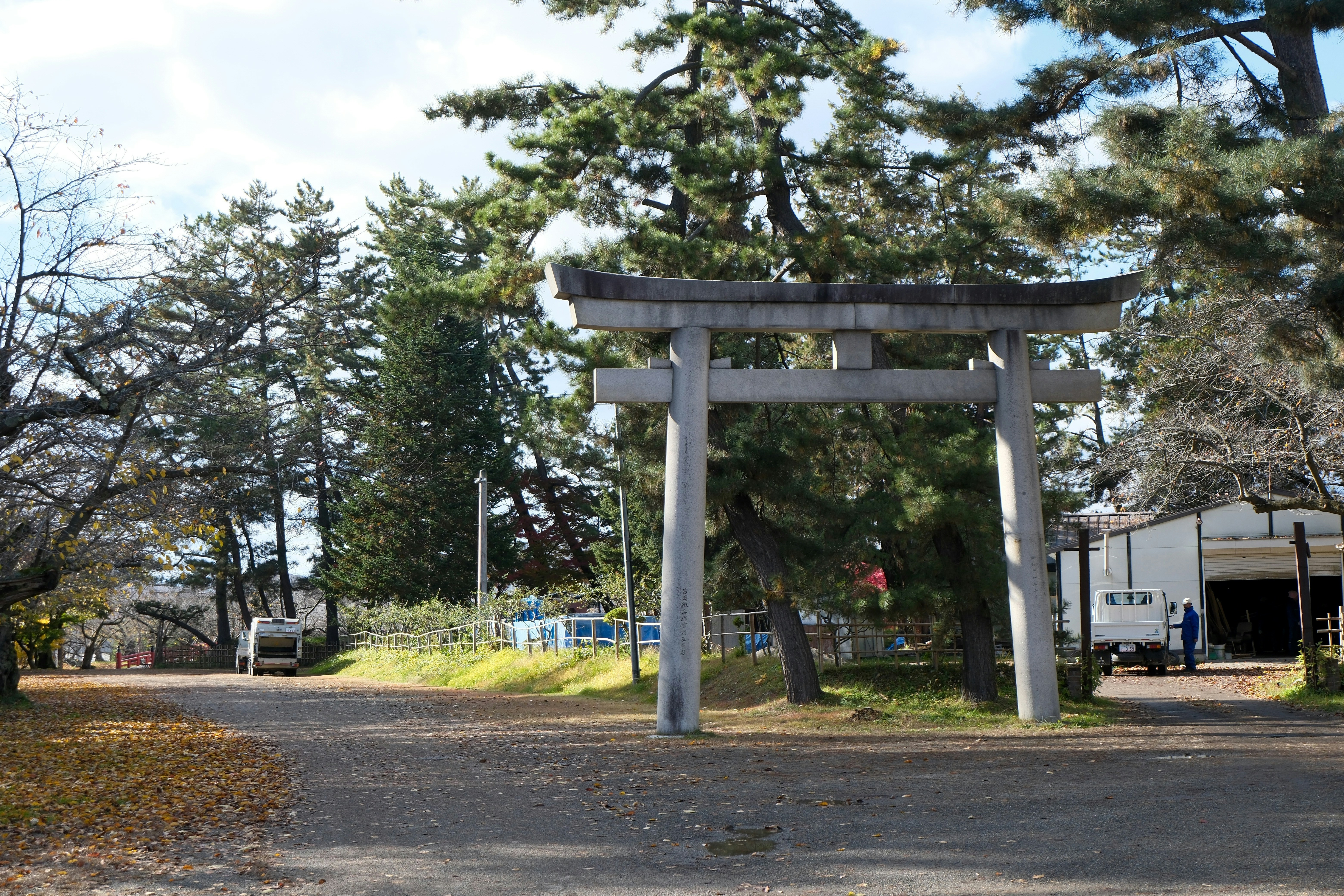Stone torii gate in a park with trees