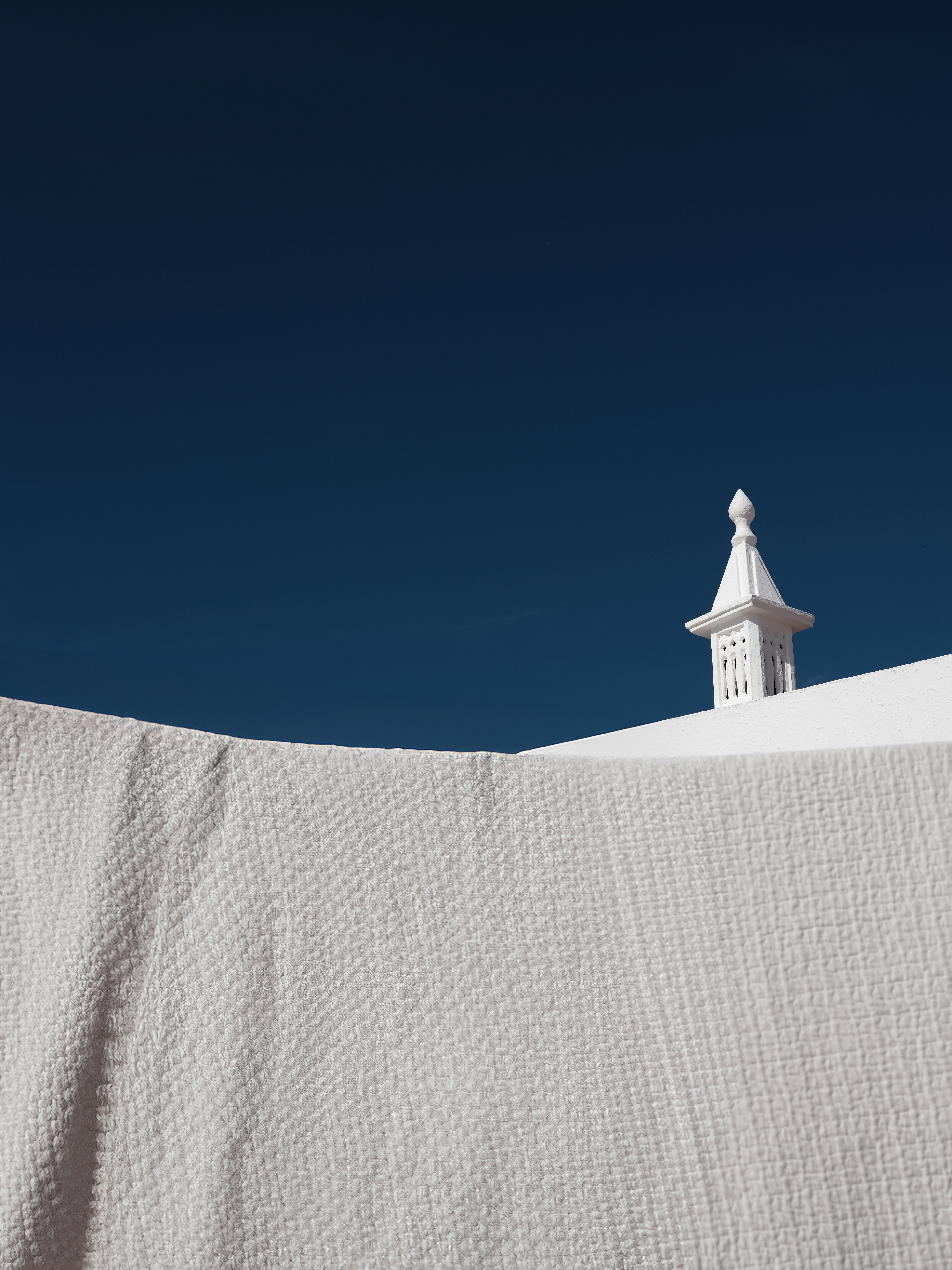 White building detail against a deep blue sky