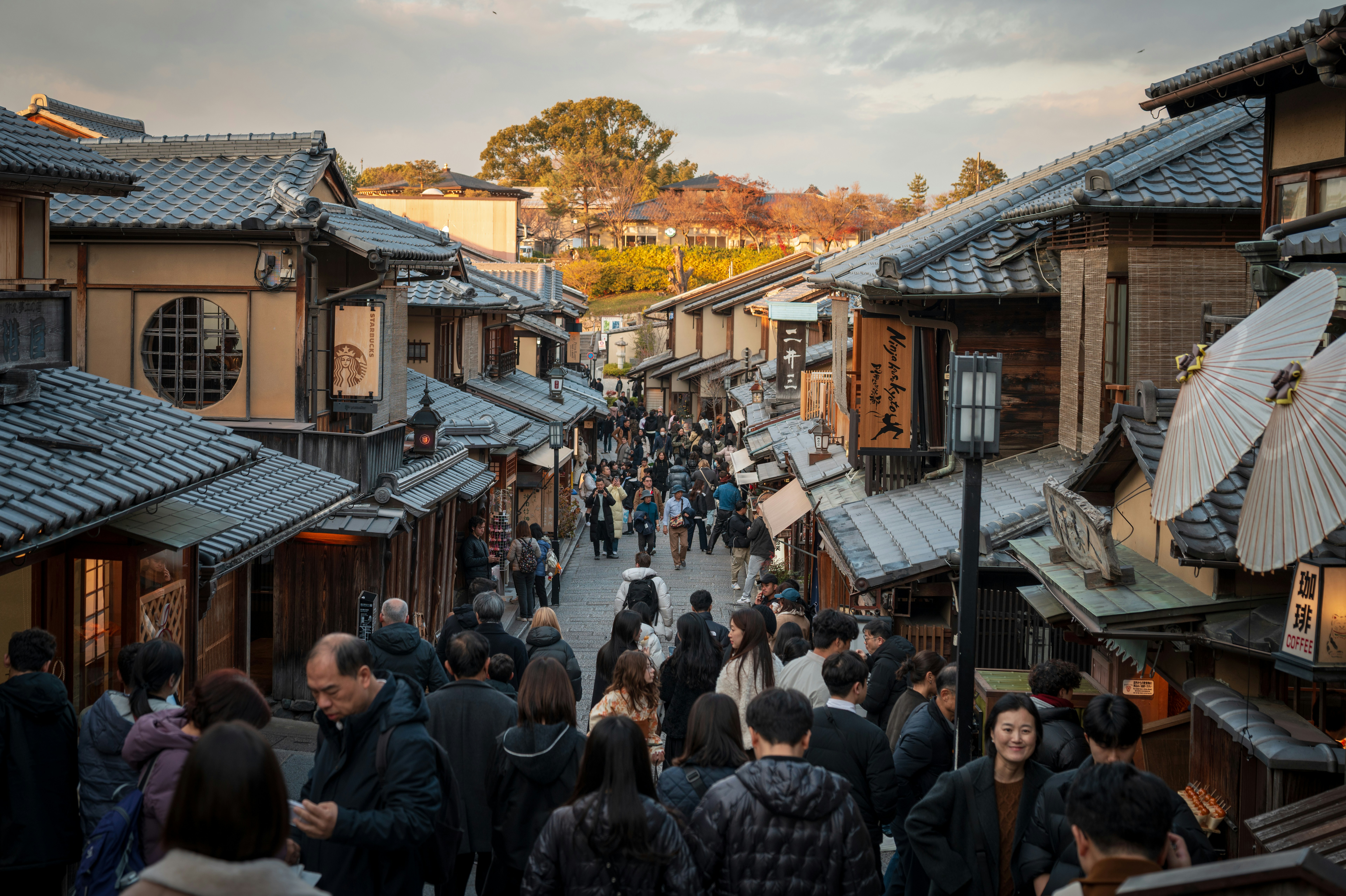 Crowded street with traditional japanese buildings and umbrellas