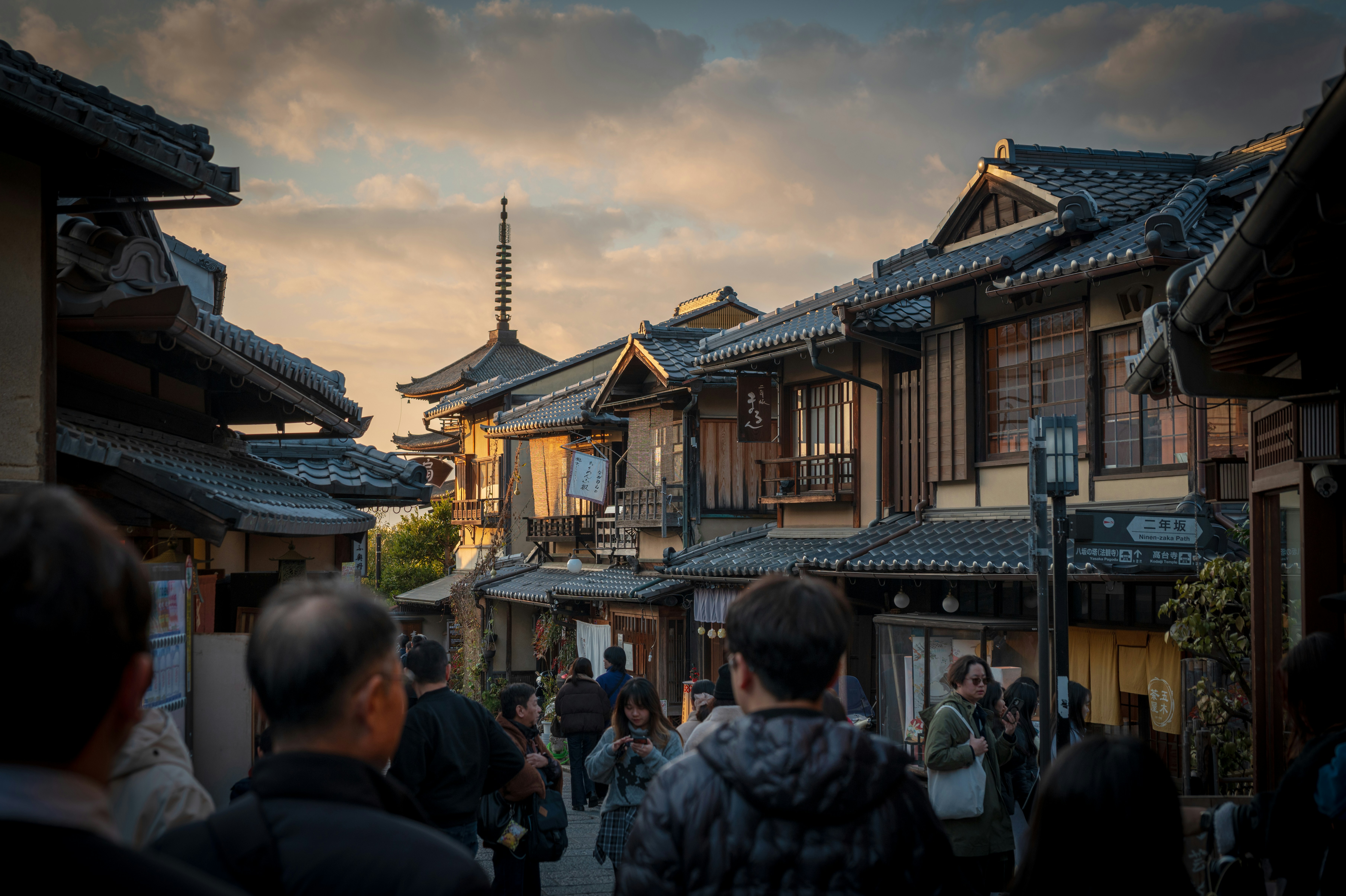 People walking down a traditional japanese street at dusk.